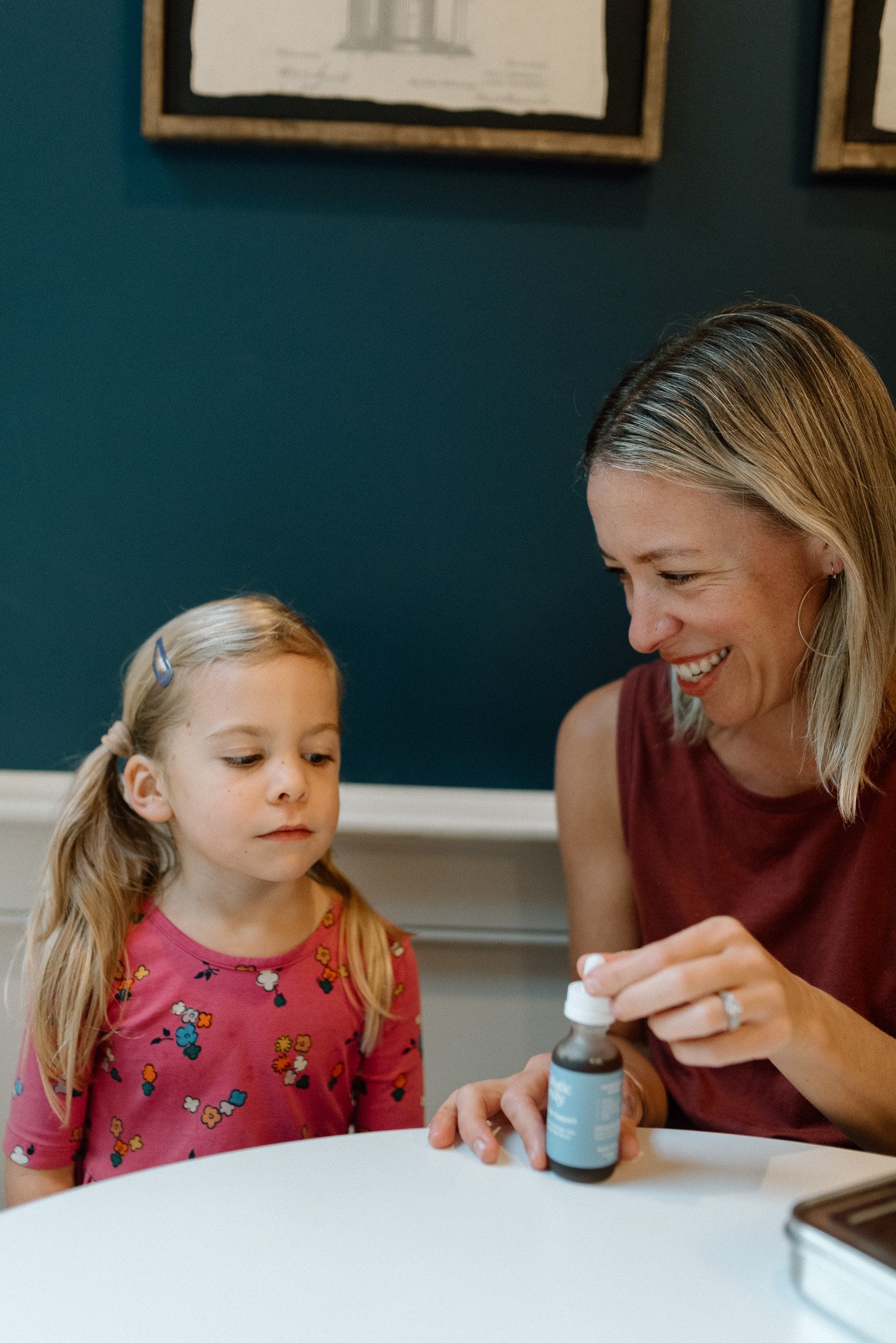 mother and child with holistic wellness dropper bottle