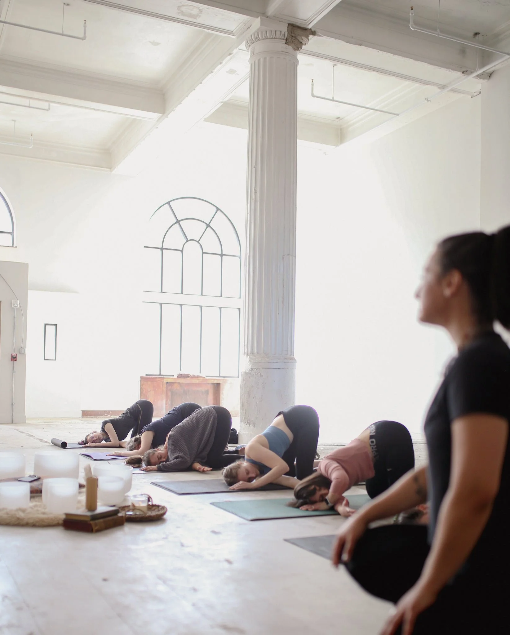A large room filled with people on mats doing yoga