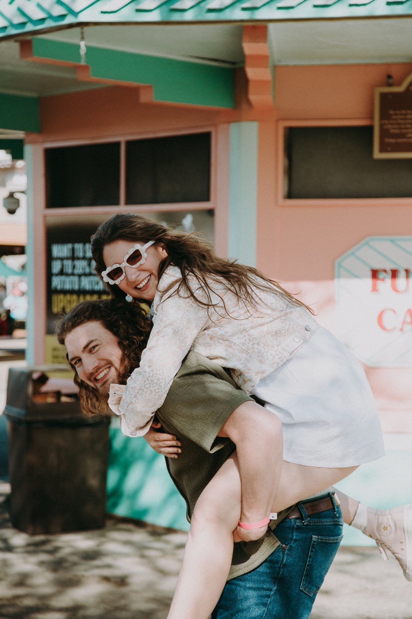 A person laughing as their partner holds them on their back 
