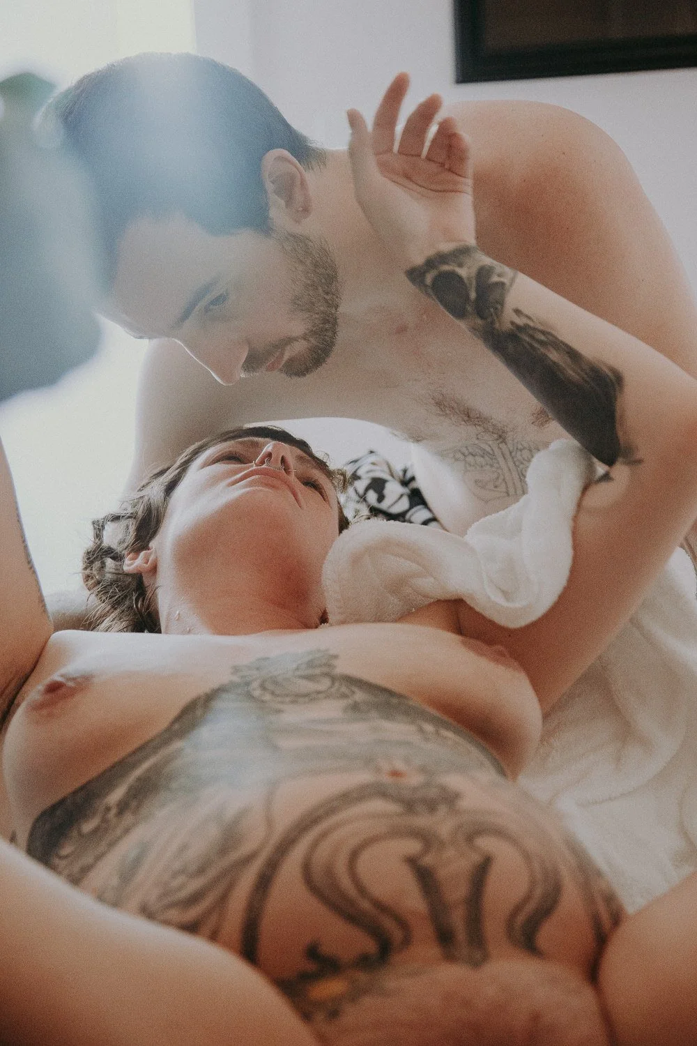 A couple laying down and leaning into each other during a birth 