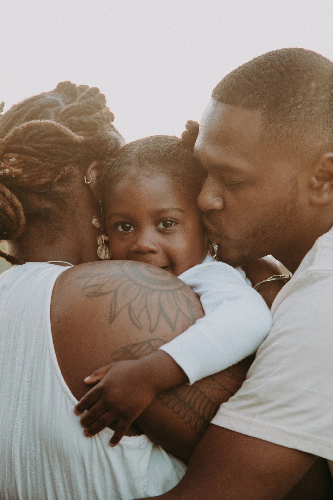 Two parents holding their child in between them 