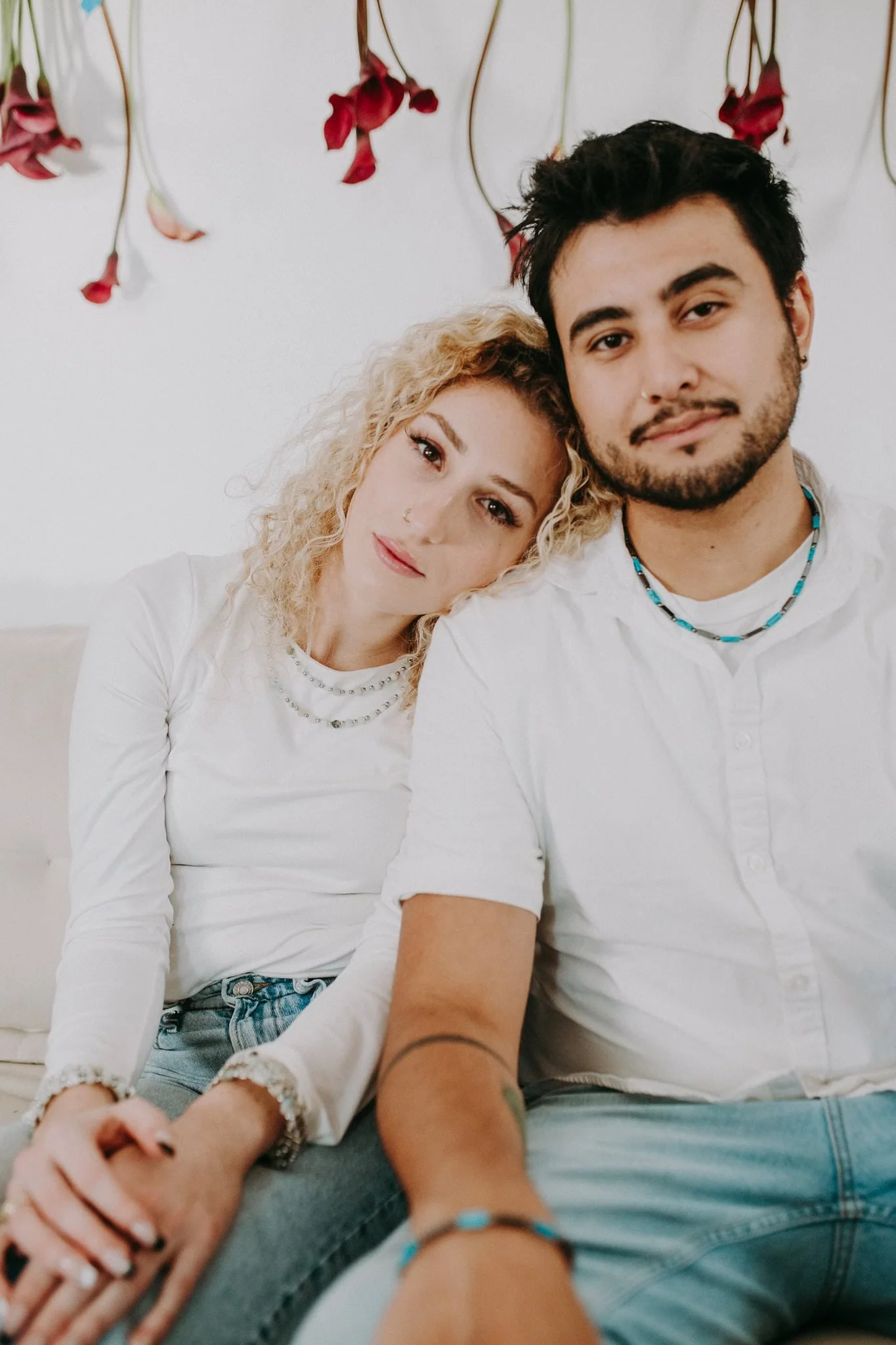 Two people sitting next to each other leaning into each other 