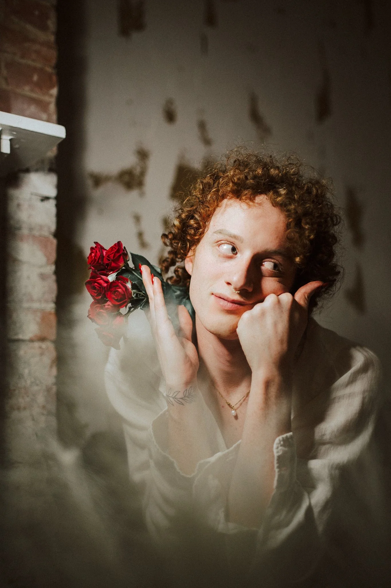 A person resting their hand on their hand while holding flowers in the other hand
