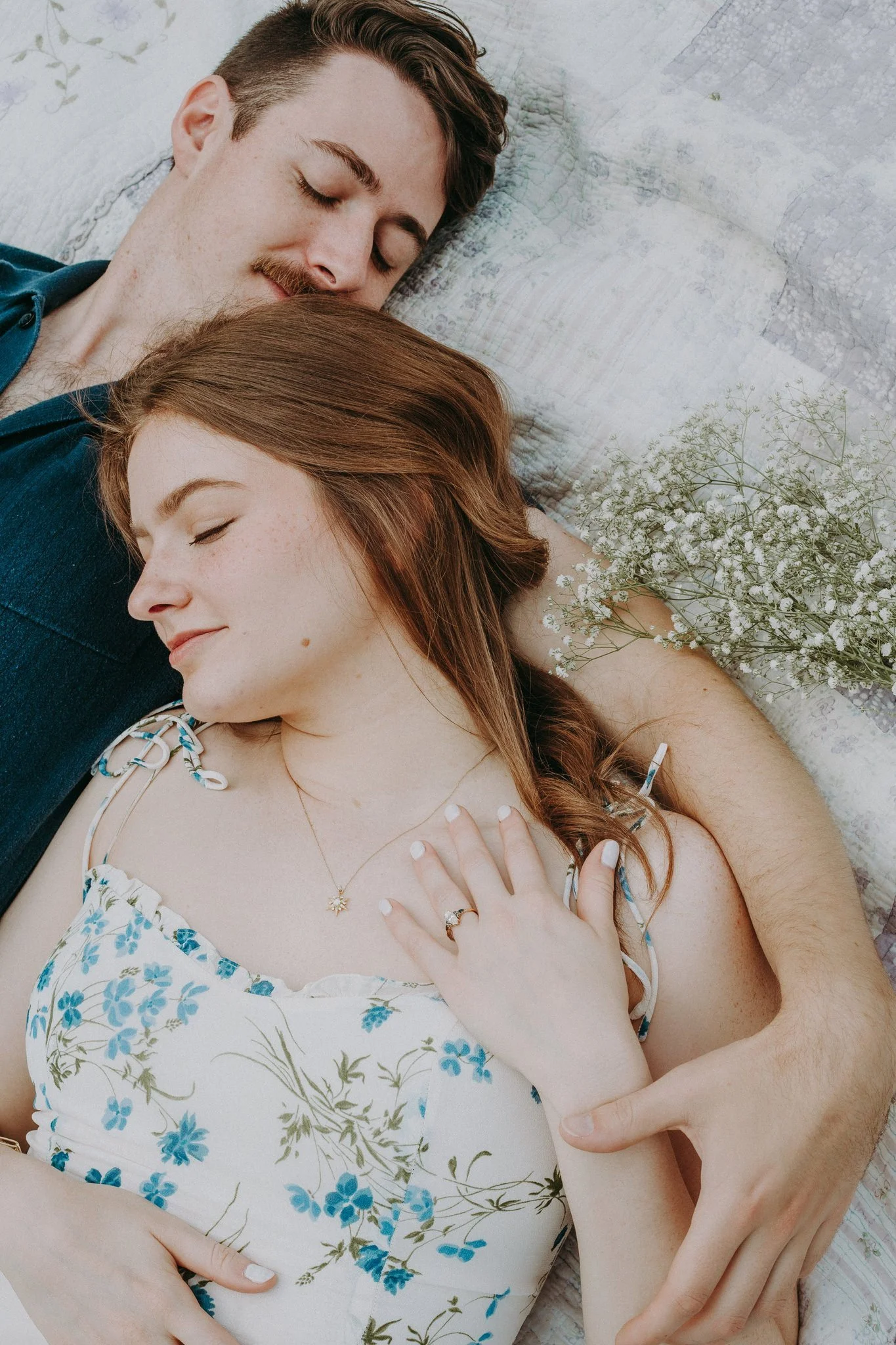A couple laying down cuddled together 