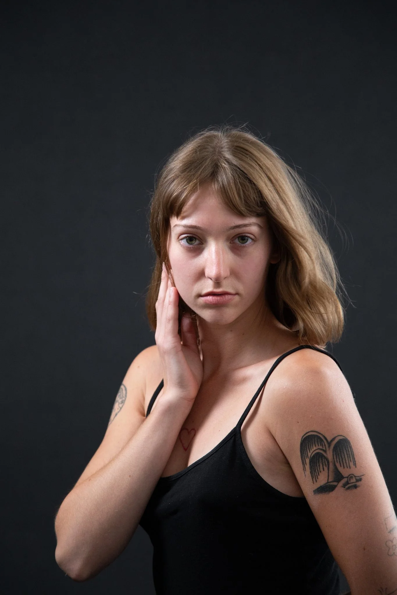 A person looking to the side with their hand on their cheek 