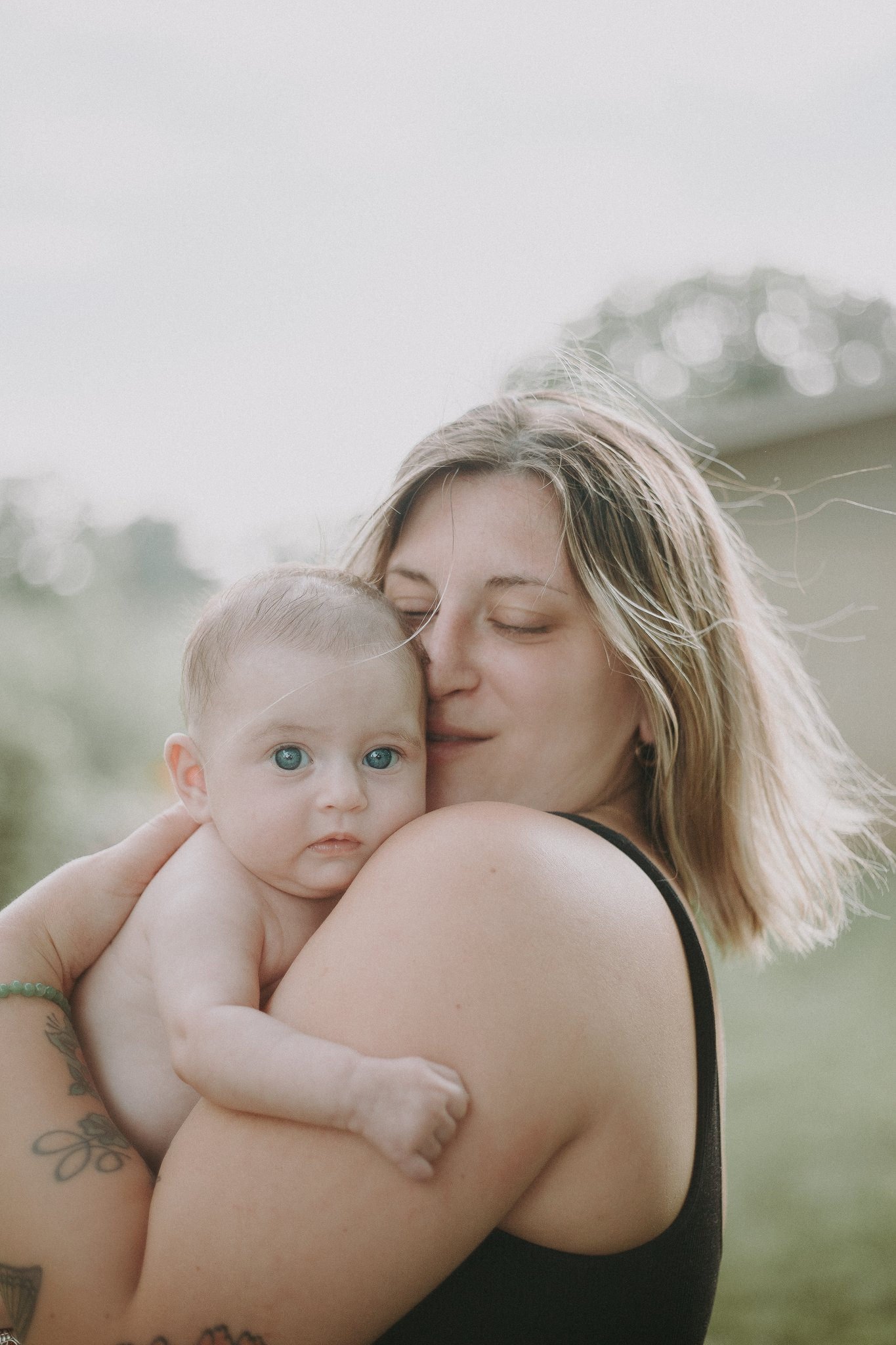 A mother holding a baby closely against their chest