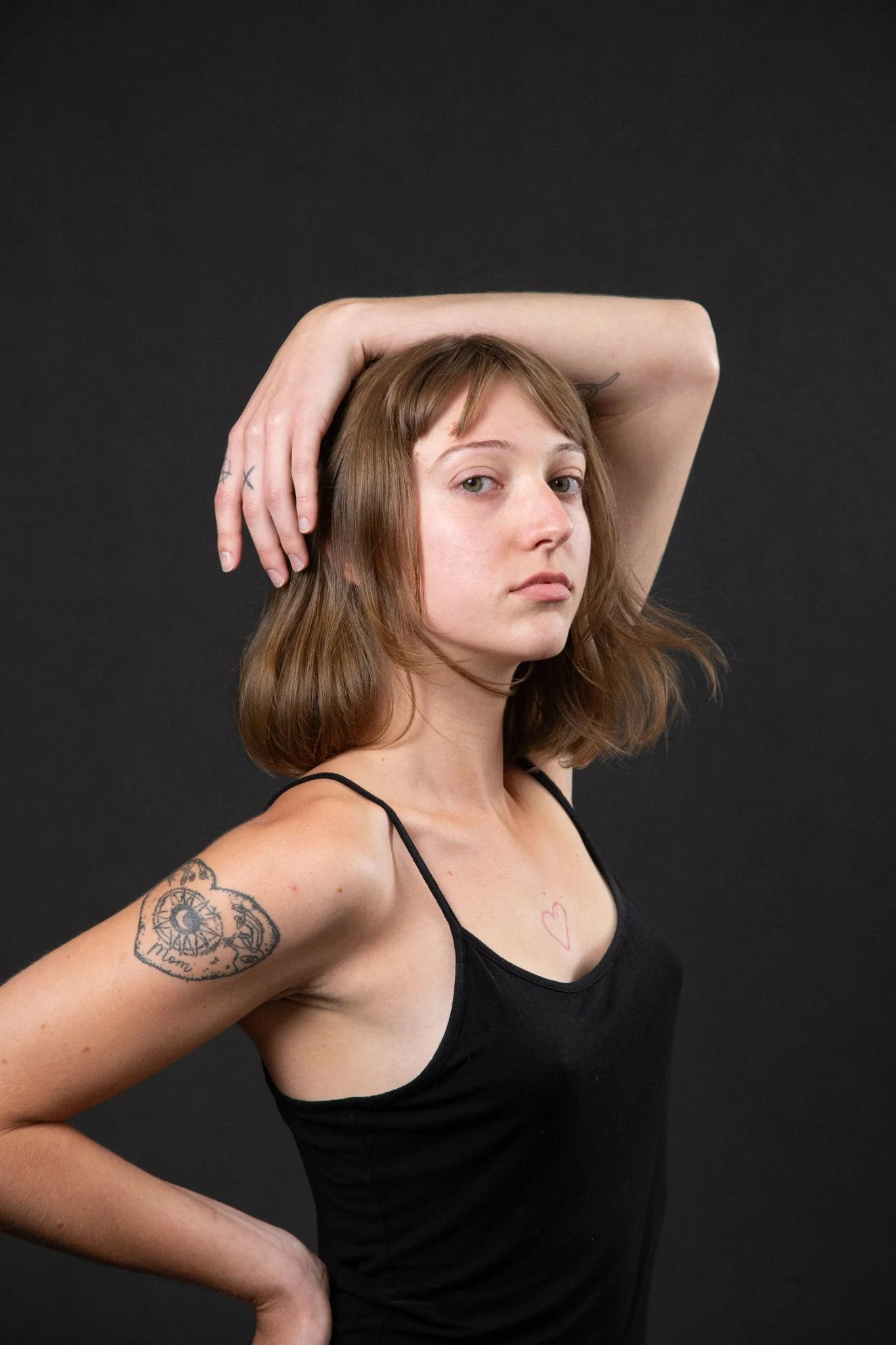 A person with one arm over their hand and the other hand on their hip