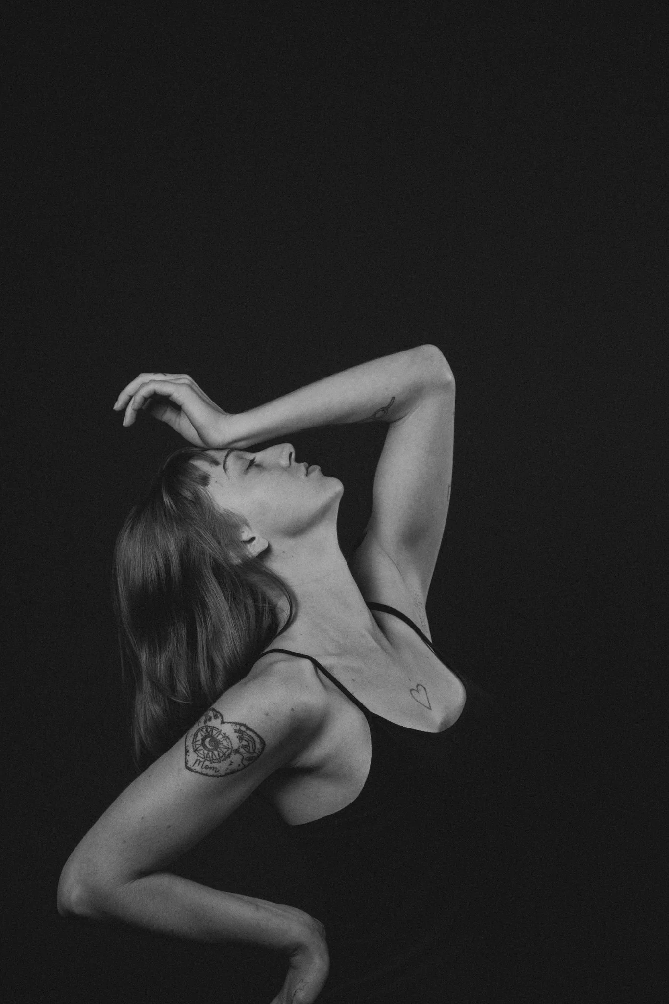 A person leaning their head back with their palm on their forehead 