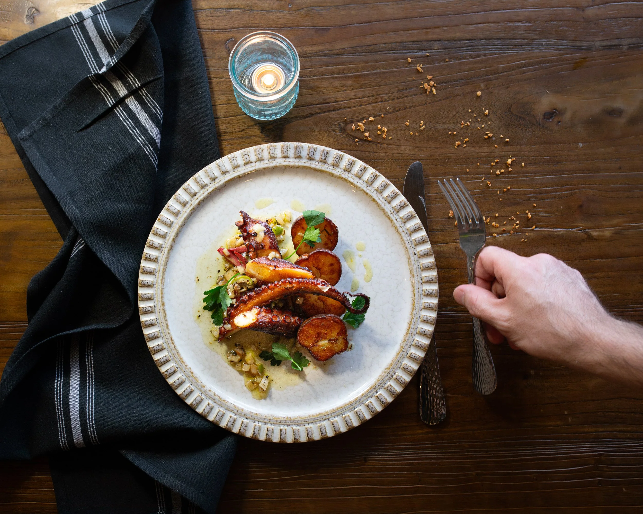 An intricate seafood dish on a plate on a wooden table