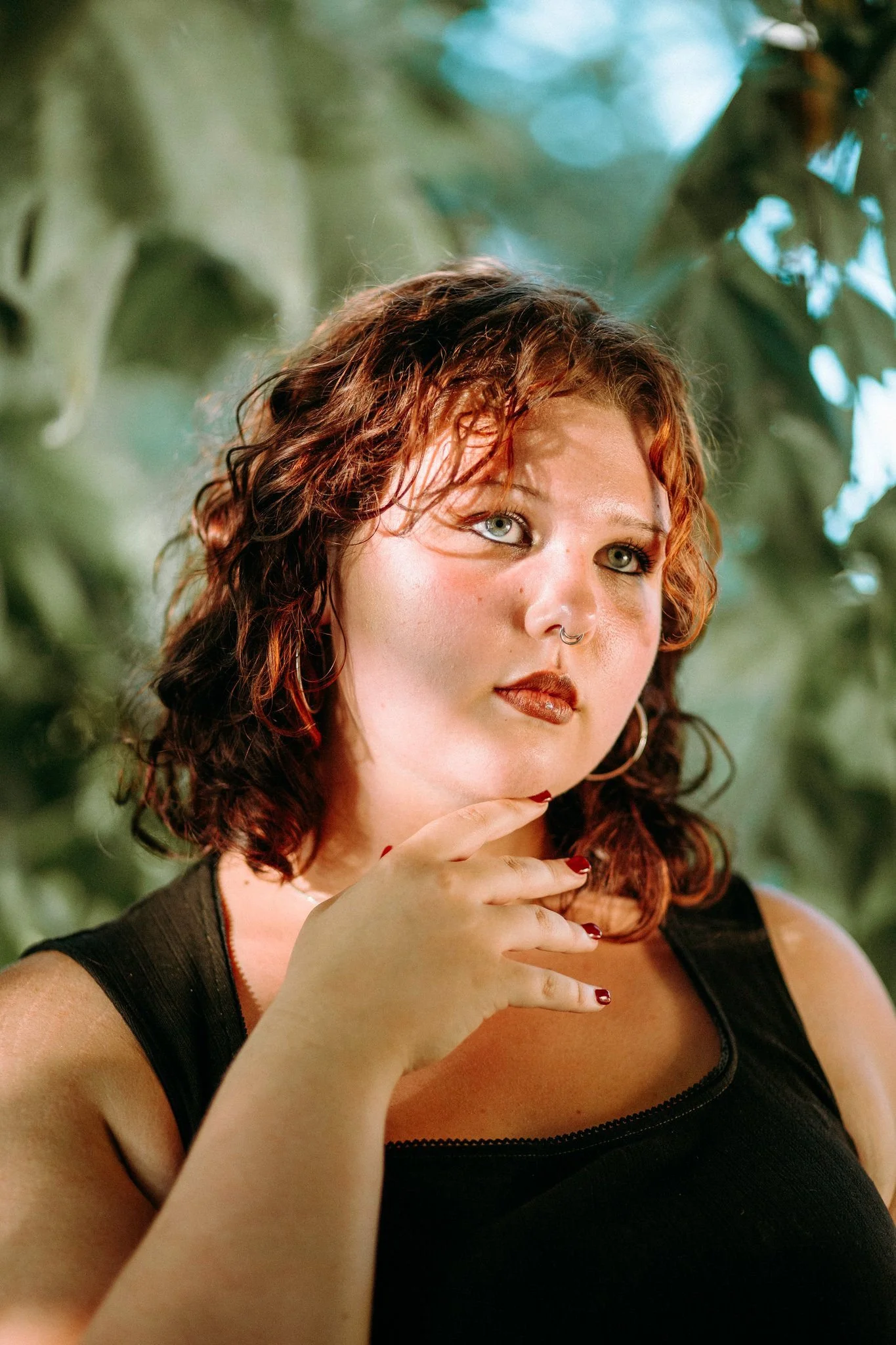 A person looking up with their hand under their chin 