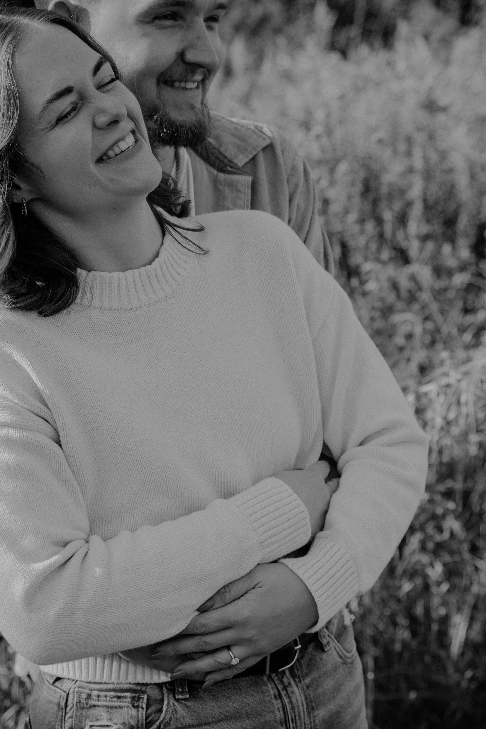 A couple with their arms around each other laughing