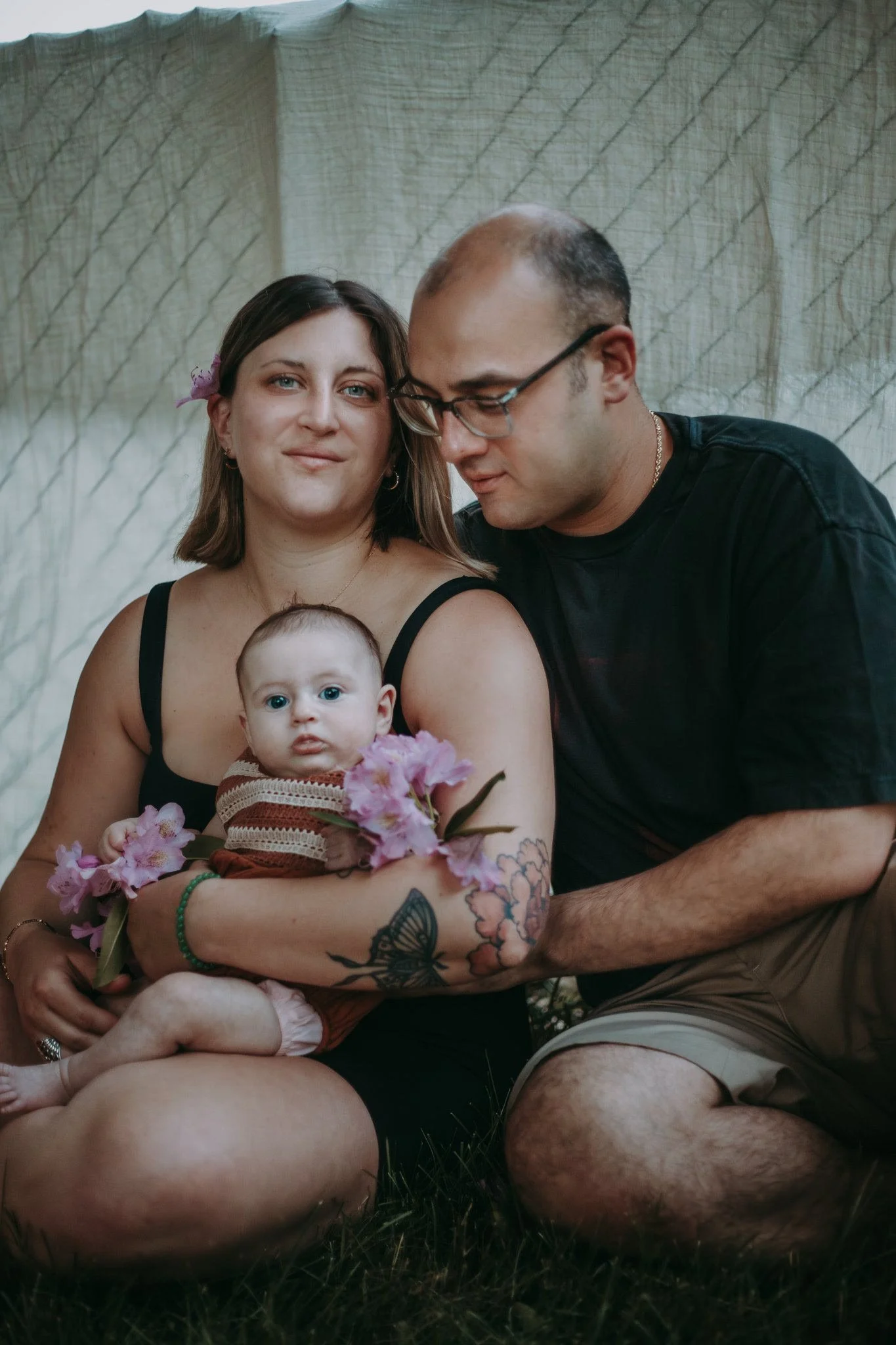 Two parents sitting together with a baby in their lap