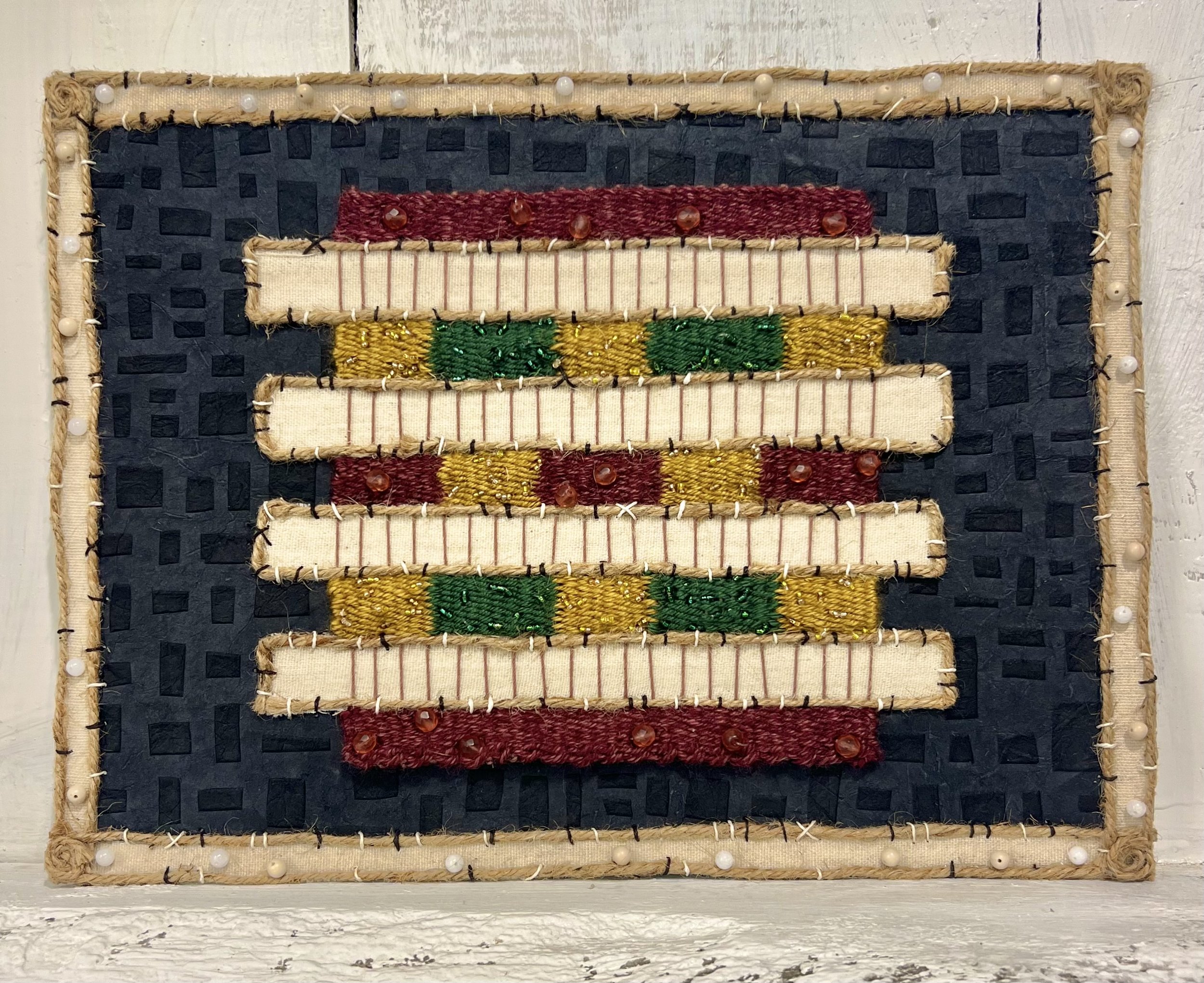 Untitled. Materials: paper, twine rope, stone/ glass beads, acrylic yarn, card stock. Year created: 2025