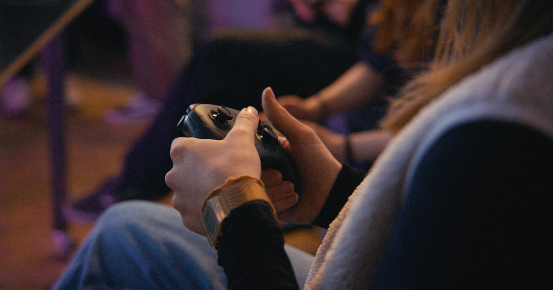 Nahaufnahme einer Person, die einen Spiele-Controller hält, in einer entspannten Umgebung.