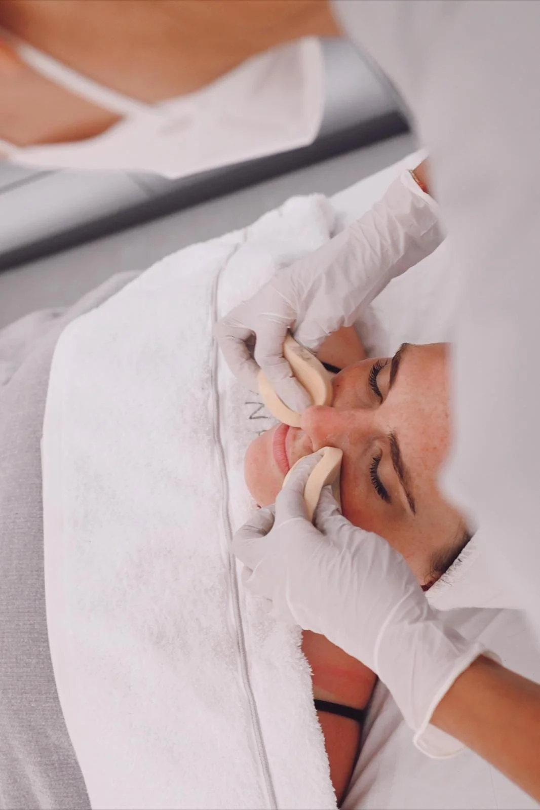 Tratamiento facial con esponja en una mujer en un spa.