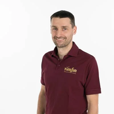 Lodewijk, bestuurder bij Timfin in een T-shirt met het logo 'timfin' op een witte achtergrond.