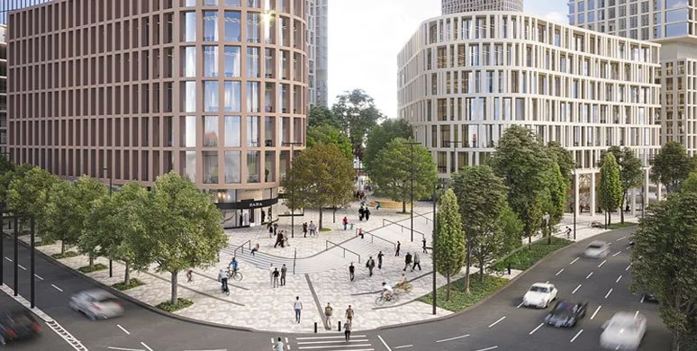Urban plaza with modern buildings, trees, and pedestrians, adjacent to a street with cars.