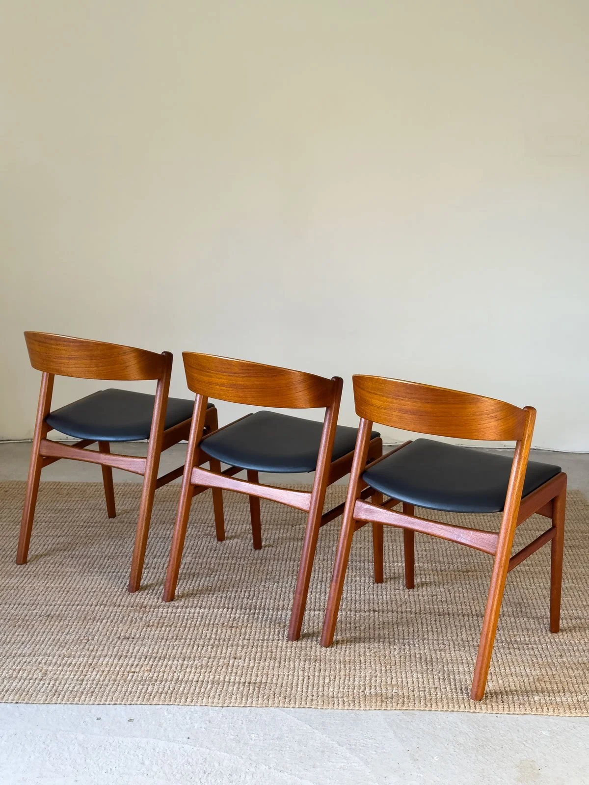 “Rear view of Erik Kirkegaard dining chair highlighting curved teak back rail”
