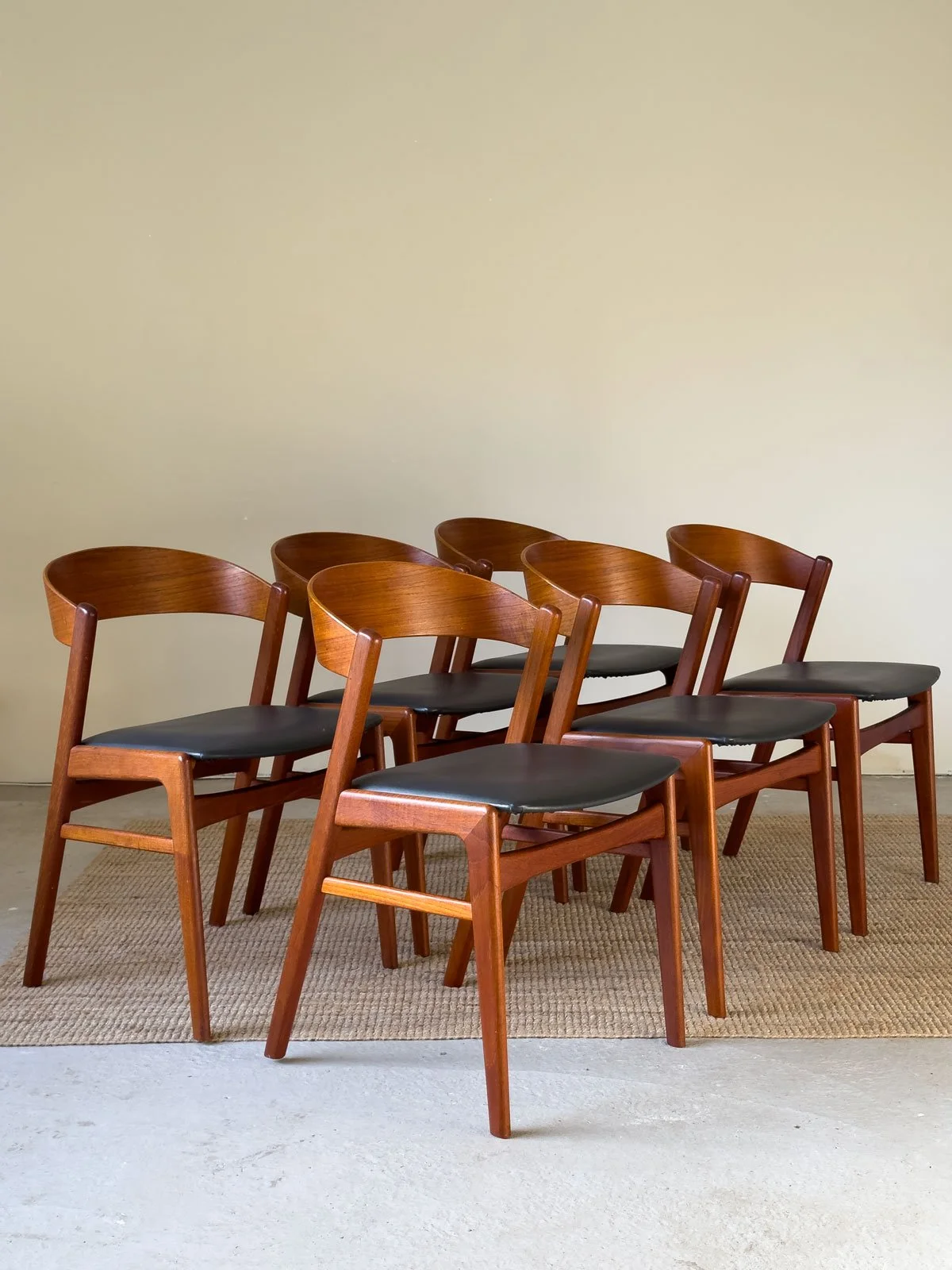 “Side view of Danish teak dining chair by Erik Kirkegaard showing sculptural backrest”