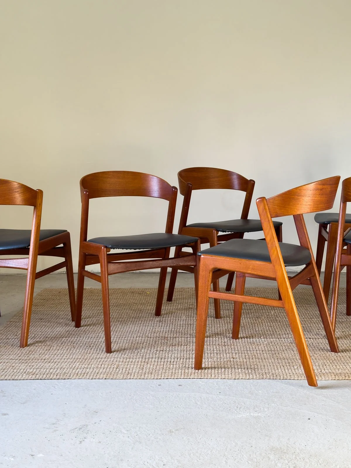 “Erik Kirkegaard teak dining chair with curved backrest and black upholstered seat”