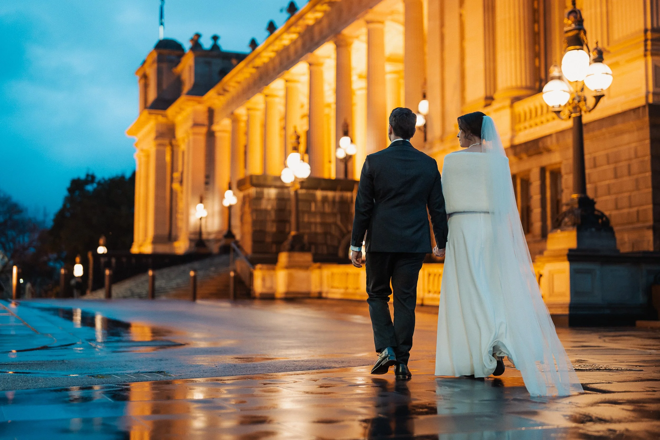 Wet Weather Photo couple walking towards Parliament House Melbourne on a rainy winter's day