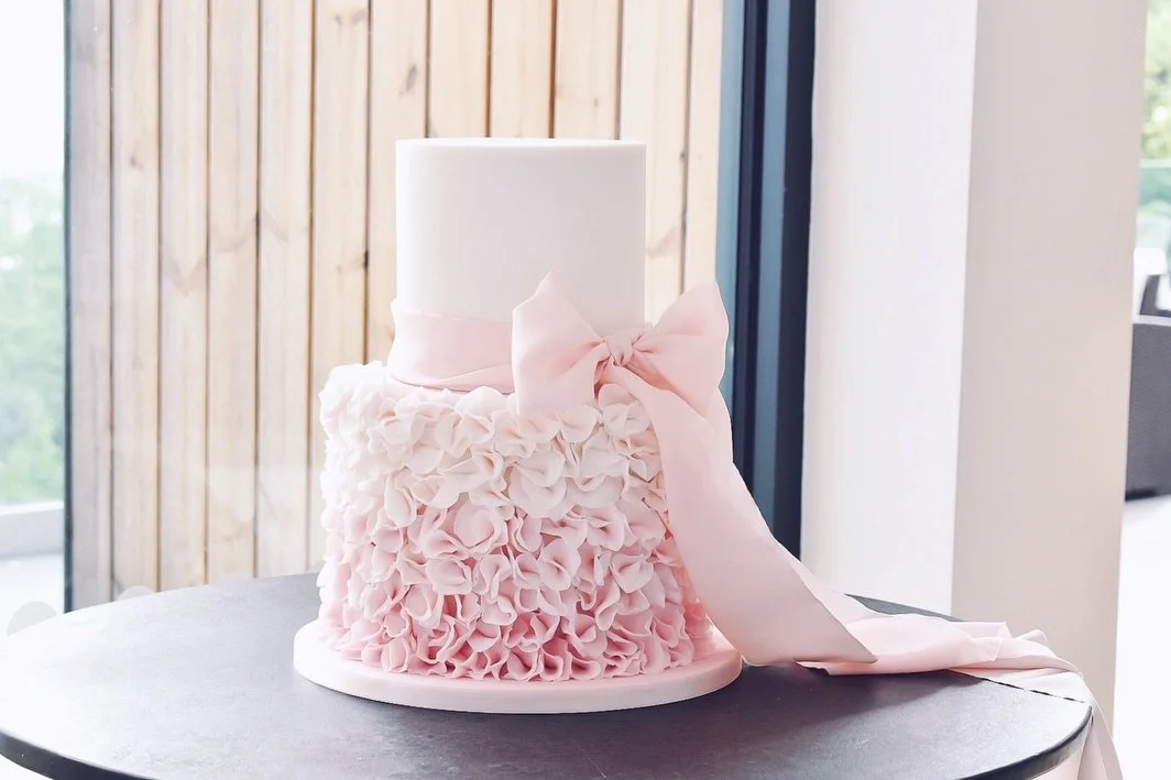 Soft ombr&eacute; blush tones ✔️ cascading ruffles ✔️ pure silk ribbon ✔️ I love making cakes like this 💗

Congratulations to the happy couple, it was an absolute pleasure making this for your special day!

Flavours: Dark Chocolate Truffle (base); C