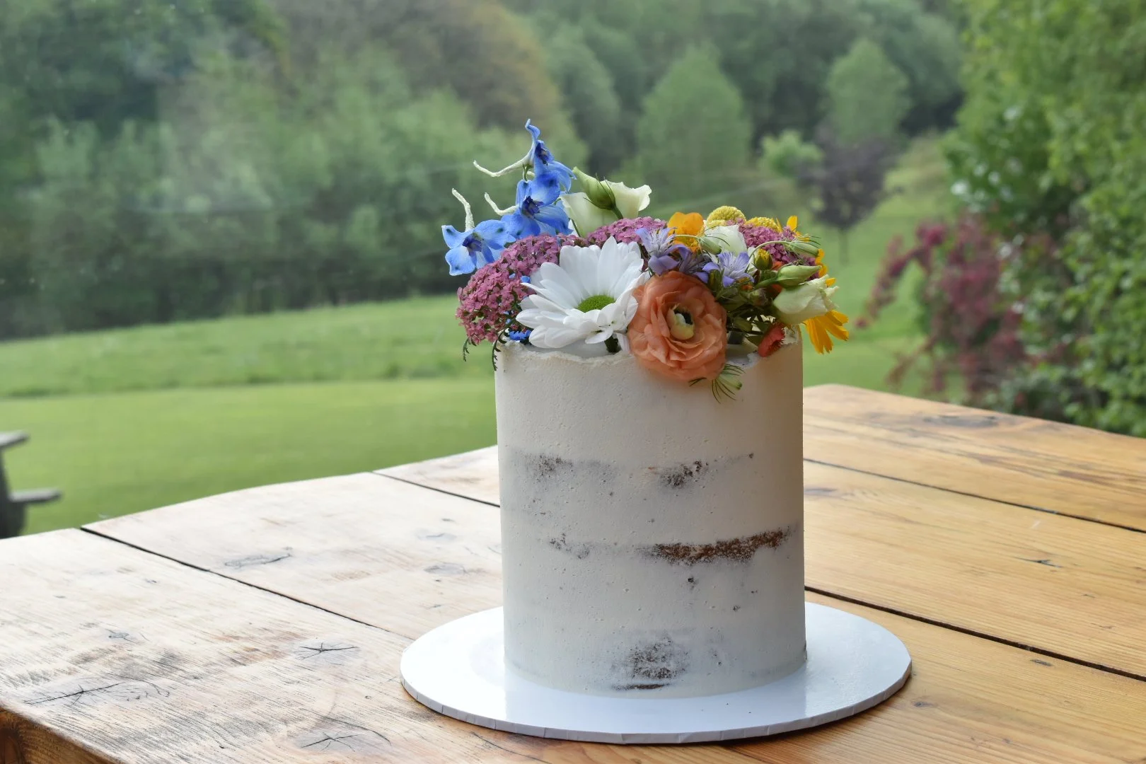 Elopement wedding cake decorated with fresh wild flowers.