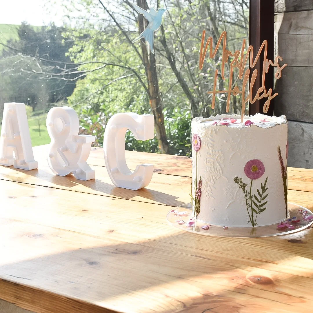 Small luxury elopement wedding cake with pressed edible flowers in Devon.