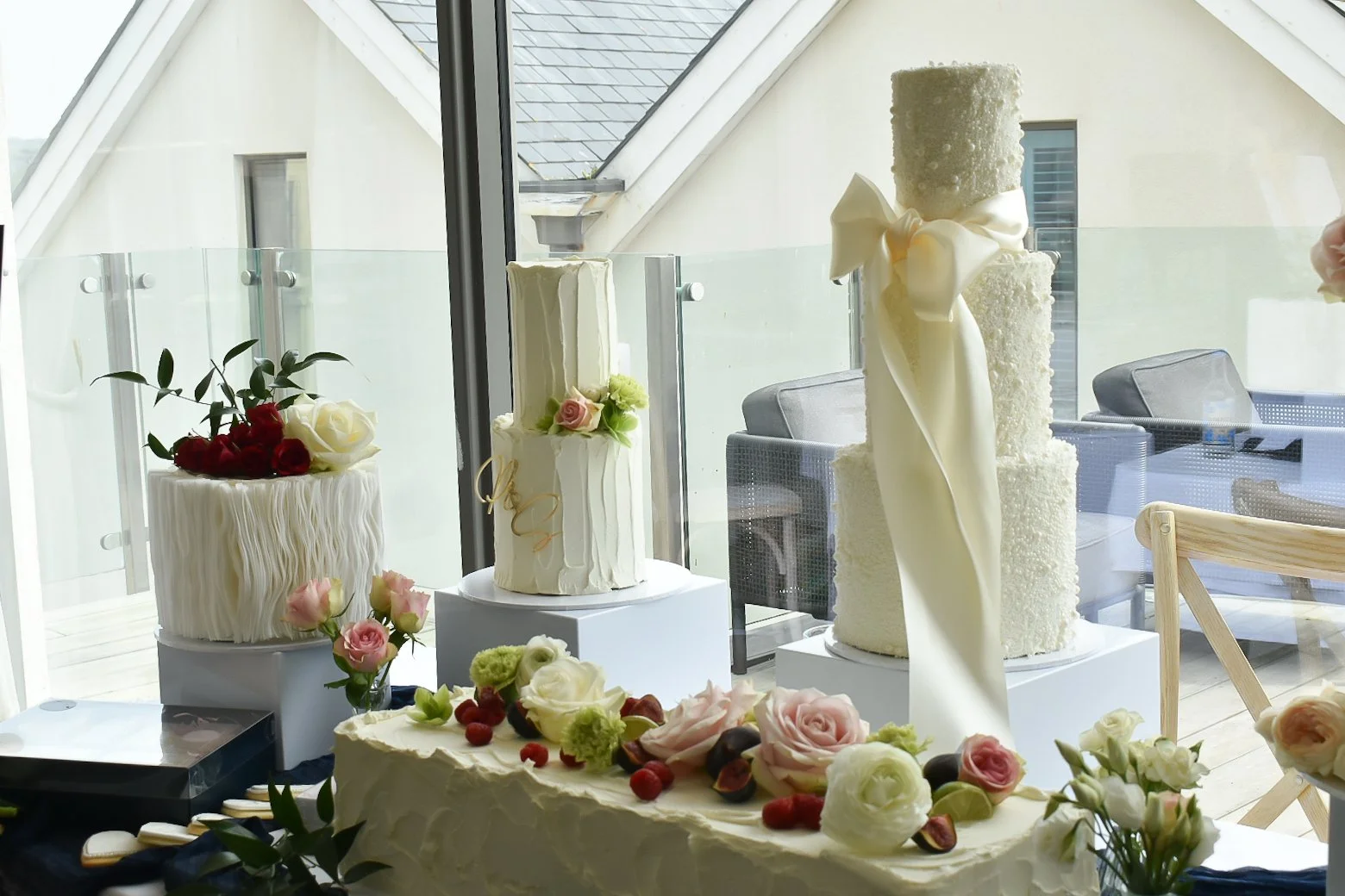 Three tier white pearl wedding cake with large bow. Wedding cake display, buttercream cakes.