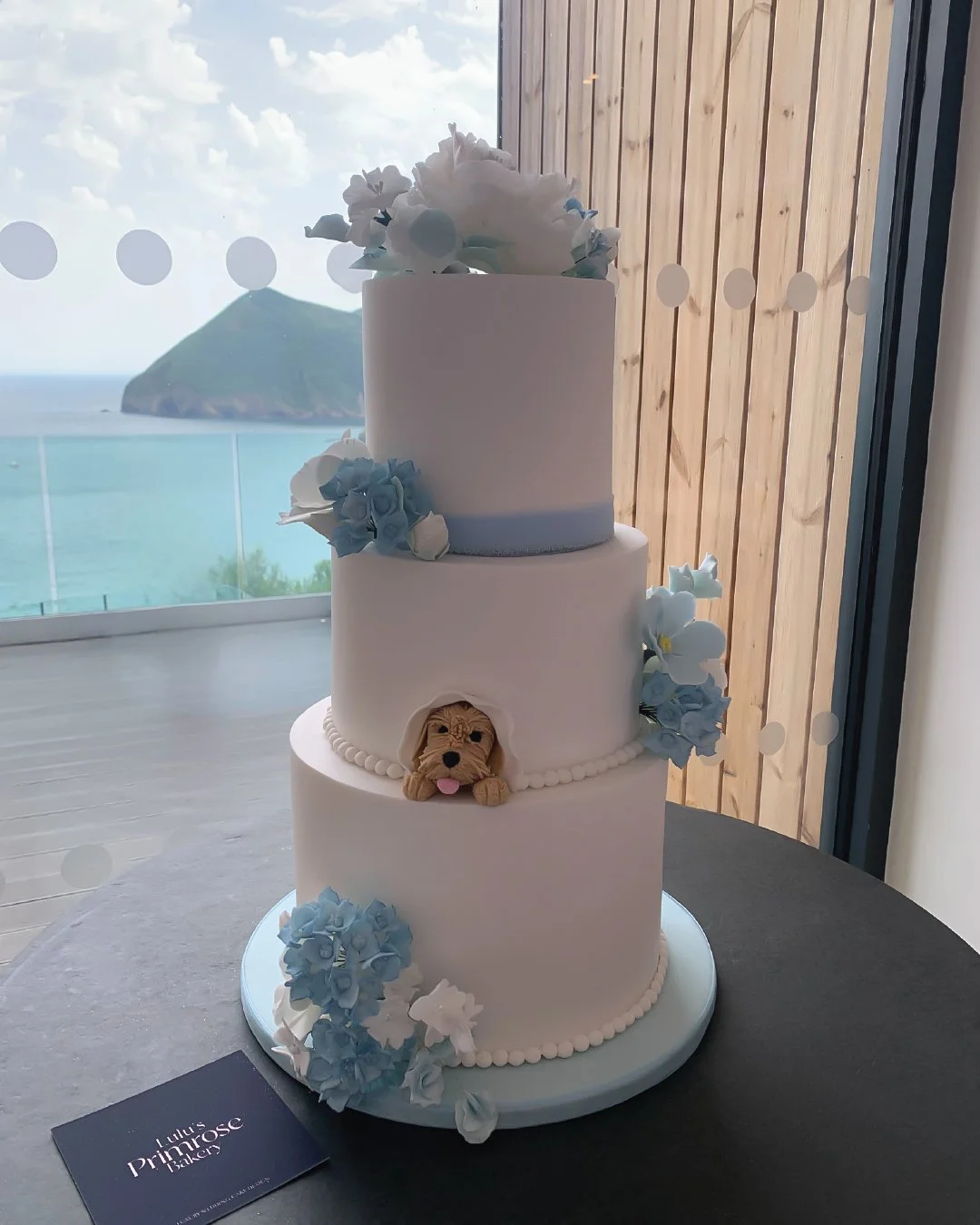 White wedding cake with pale blue colour sheme and handmade flowers. 