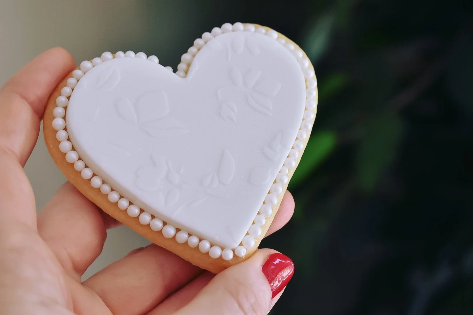 Heart-shaped iced wedding favour biscuits with embossing and pearl detail
