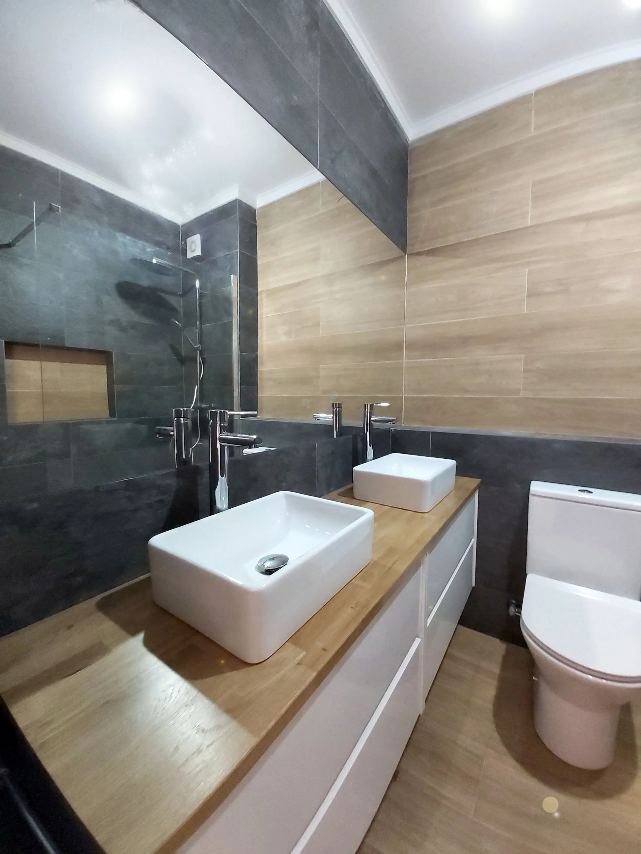 Casa-de-banho com pavimento e apontamentos em cerâmica imitação de madeira, e restante revestimento em azulejos imitação xisto