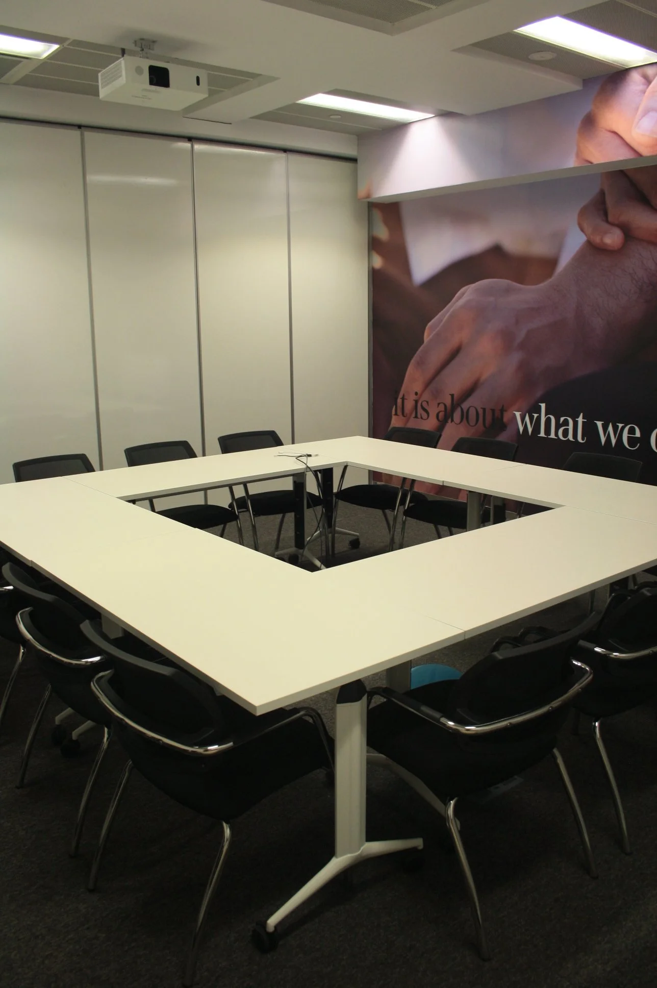 Sala de formação com mobiliário modular e parede amovível