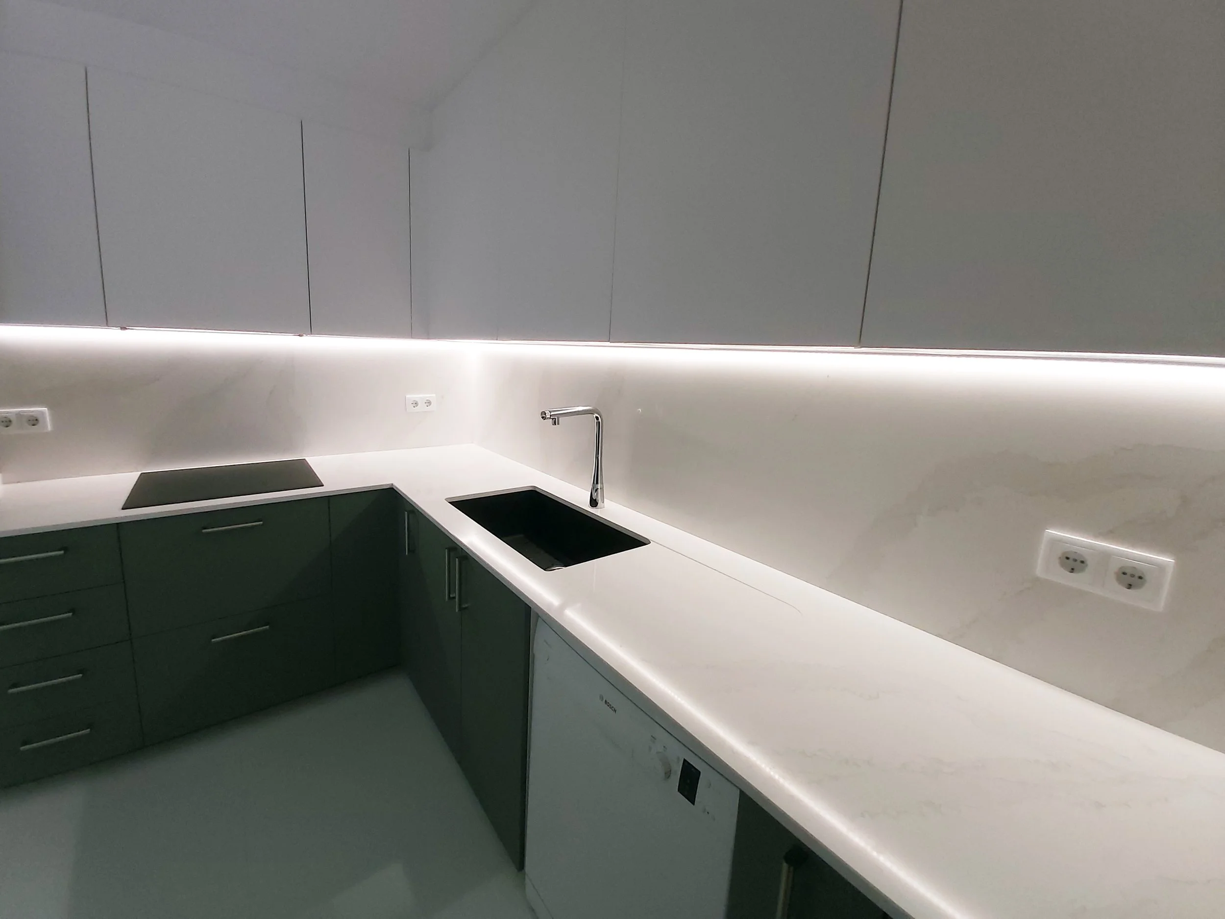 Cozinha com península e tampos e backsplash em silstone calacatta gold. Iluminação suspensa e indireta