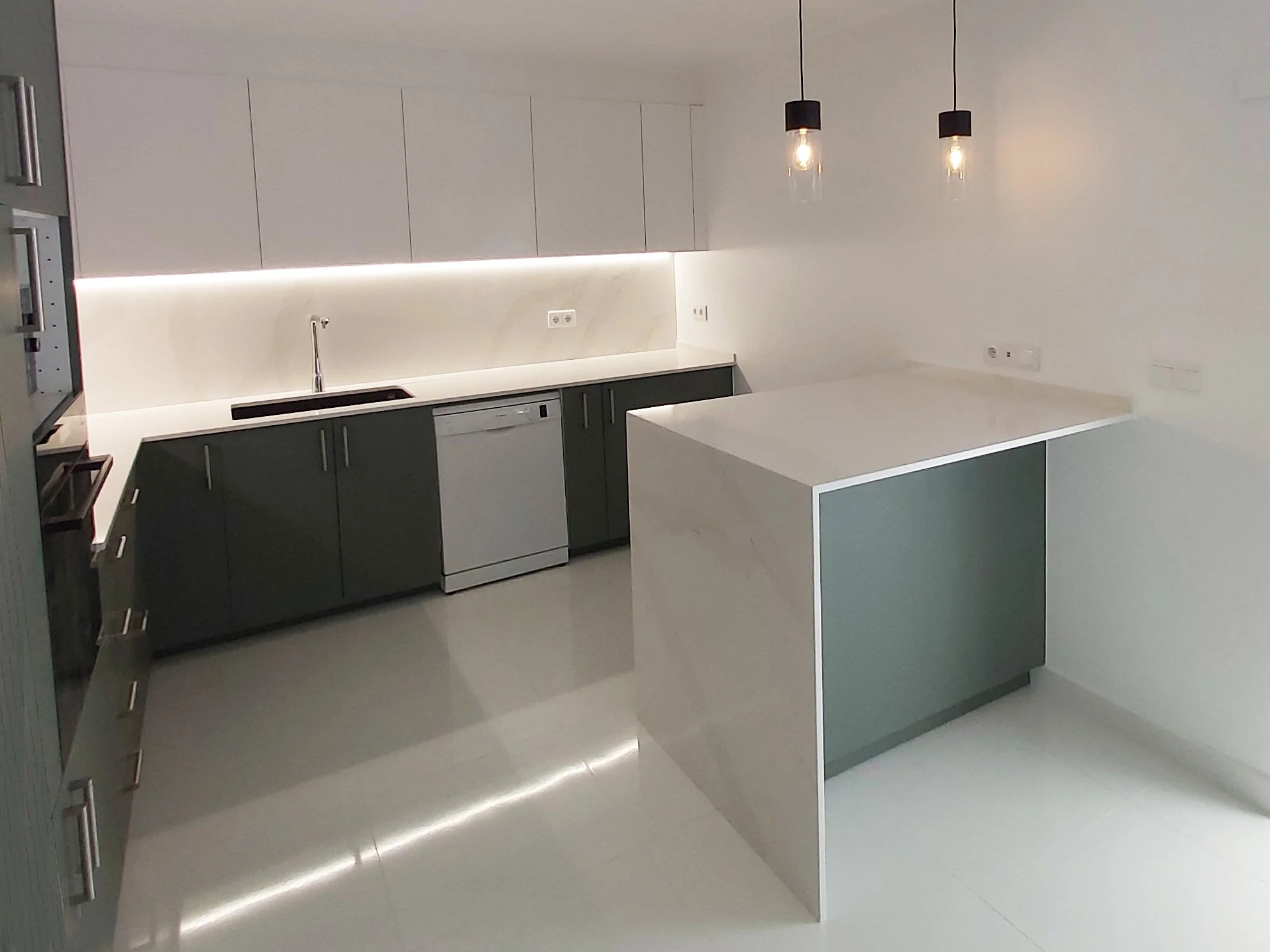 Cozinha com península e tampos e backsplash em silstone calacatta gold. Iluminação suspensa e indireta