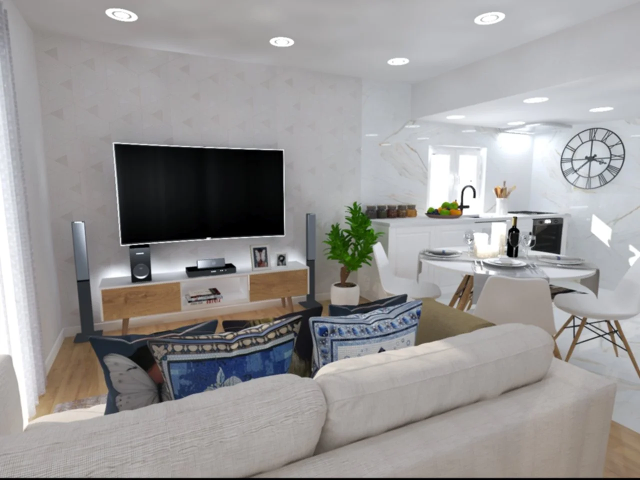 Sala de estar com televisão, sofá, almofadas azuis, e uma planta em um vaso branco, além de uma área de cozinha com mesa de jantar, janelas, relógio de parede e utensílios.