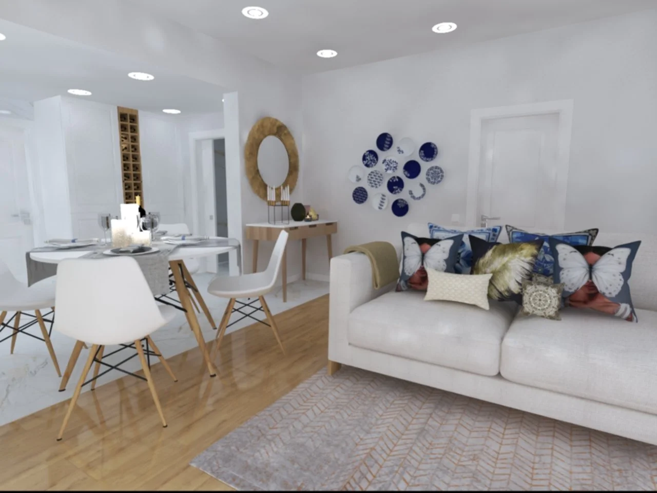 Home Staging de Moradia, Torres Vedras.
Sala de estar com sofá branco decorado com almofadas de borboleta e outras imagens, uma mesa de jantar redonda com cadeiras brancas, parede com decoração em azul e branco, espelho de parede e piso de madeira.