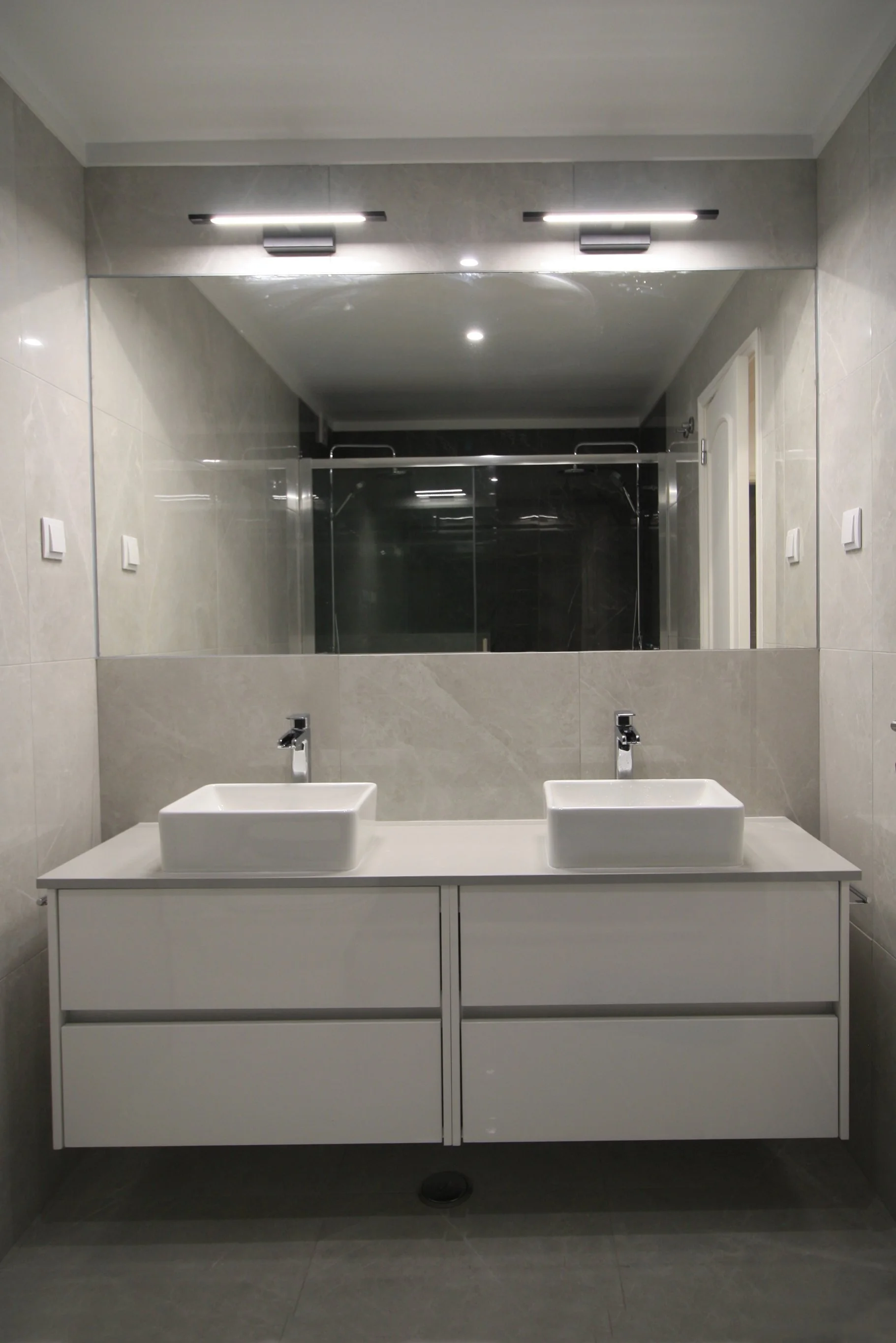 Casa de banho com armário/lavatório duplo suspenso e espelho de grande formato