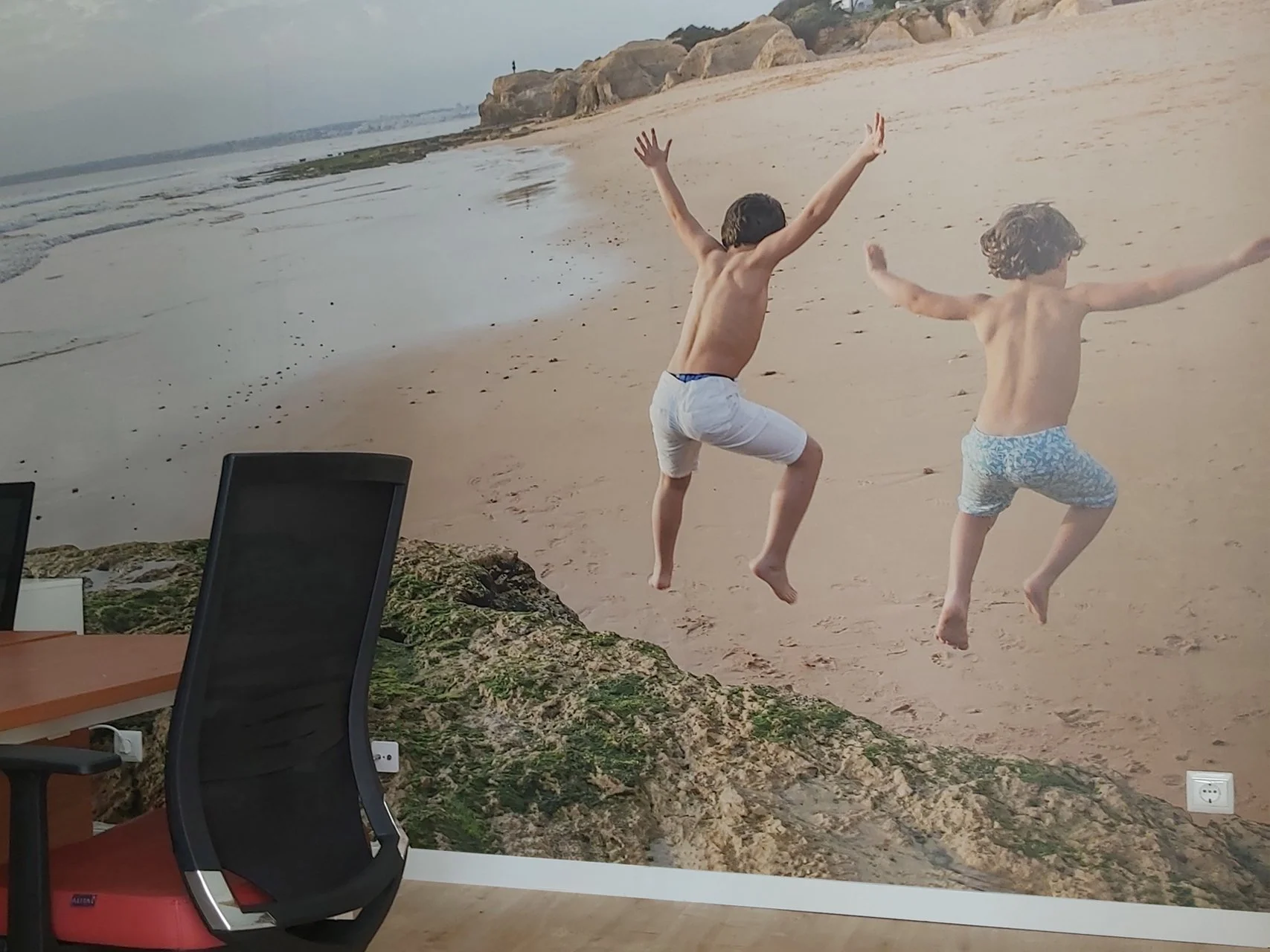 Impressão de grande formato de 2 crianças a brincar e saltar na praia.