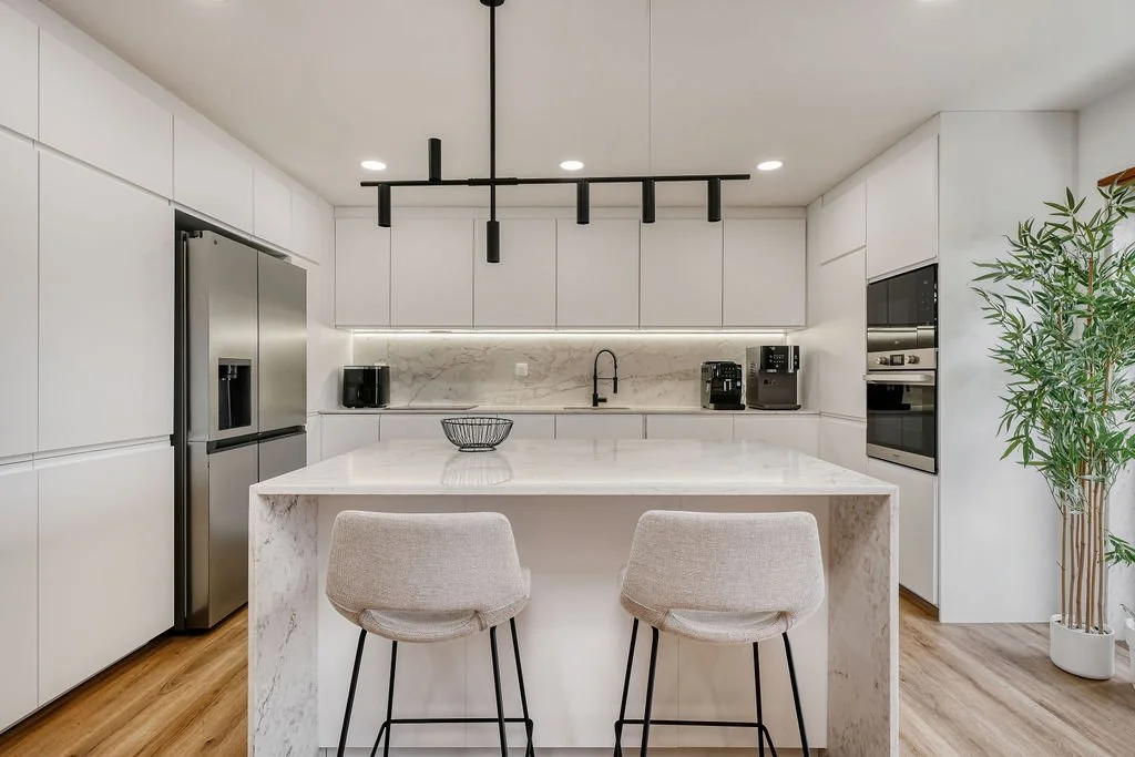 Decoração de cozinha contemporânea em open space com ilha e candeeeiro suspenso. Tampos e backsplash em silstone callacata gold