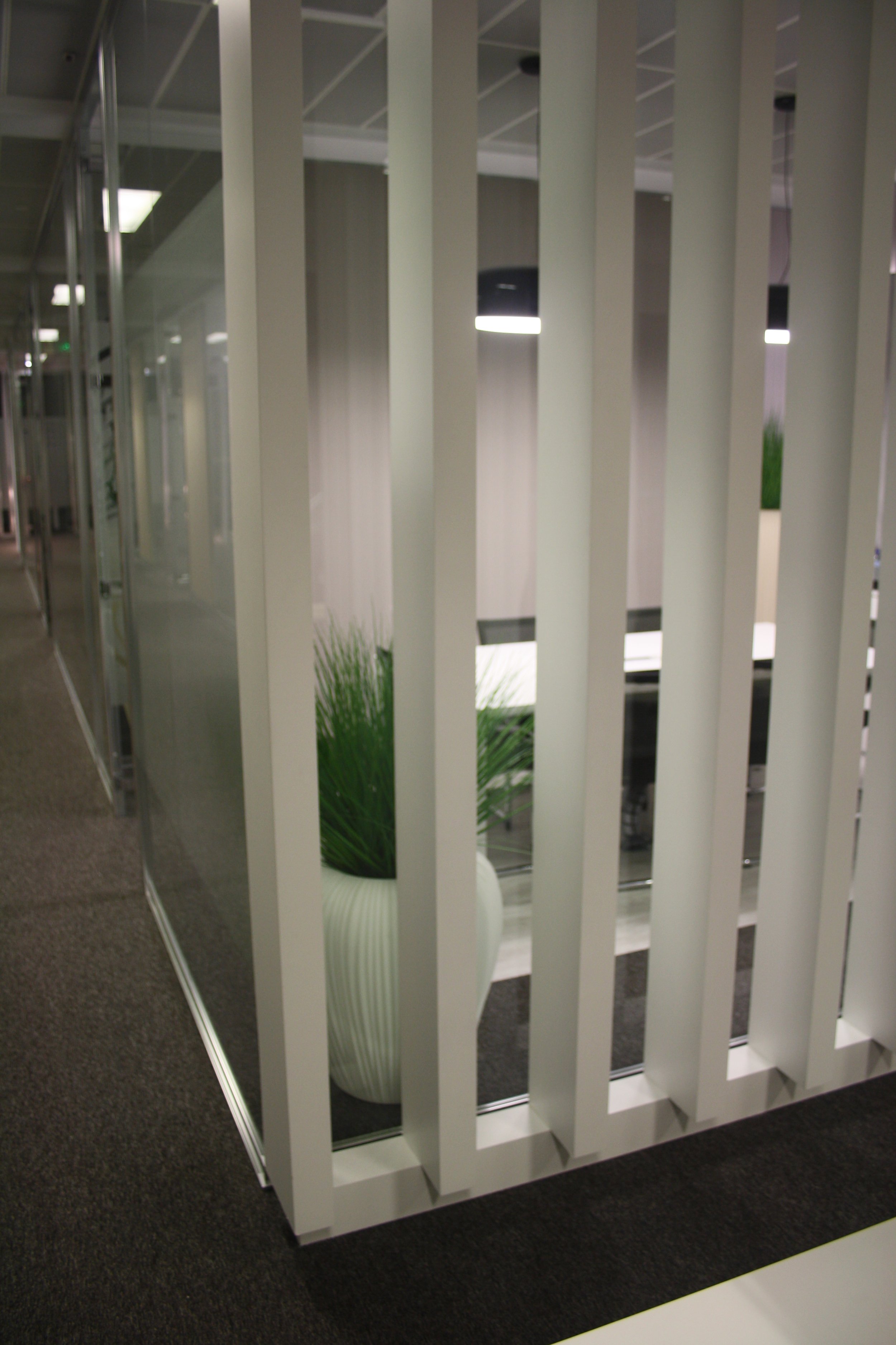 Divisória de Quiet Room em ripado e divisória em vidro com aplicação de vinil frost.