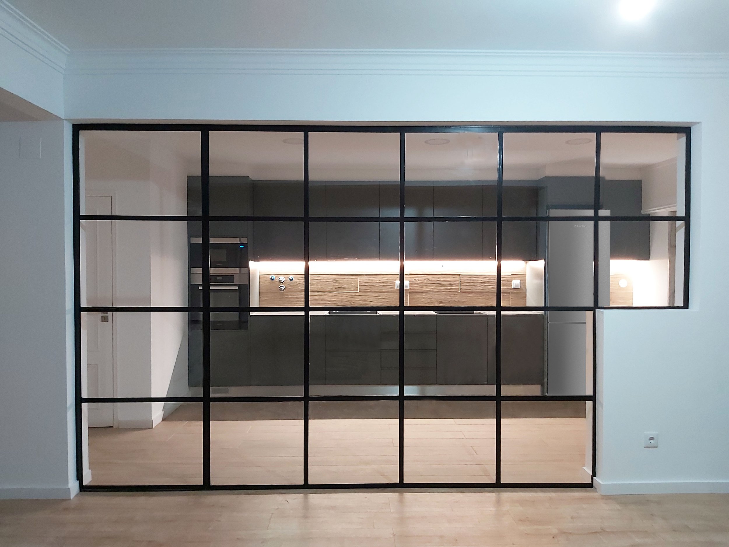 Divisória em metal com porta oculta, estilo industrial, para separação entre sala e cozinha, em apartamento na Quinta Grande,  Alfragide