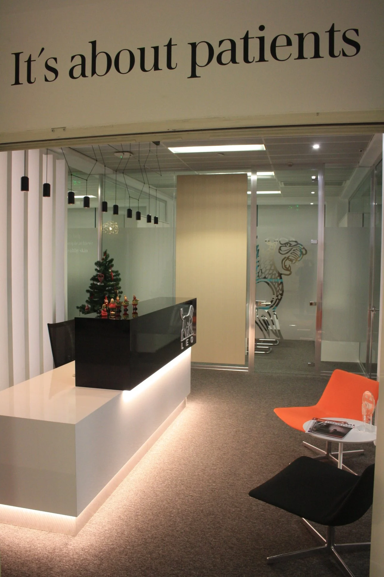 Balcão de recepção com iluminação integrada, candeeiro suspenso e painel ripado retro iluminado. área de espera.