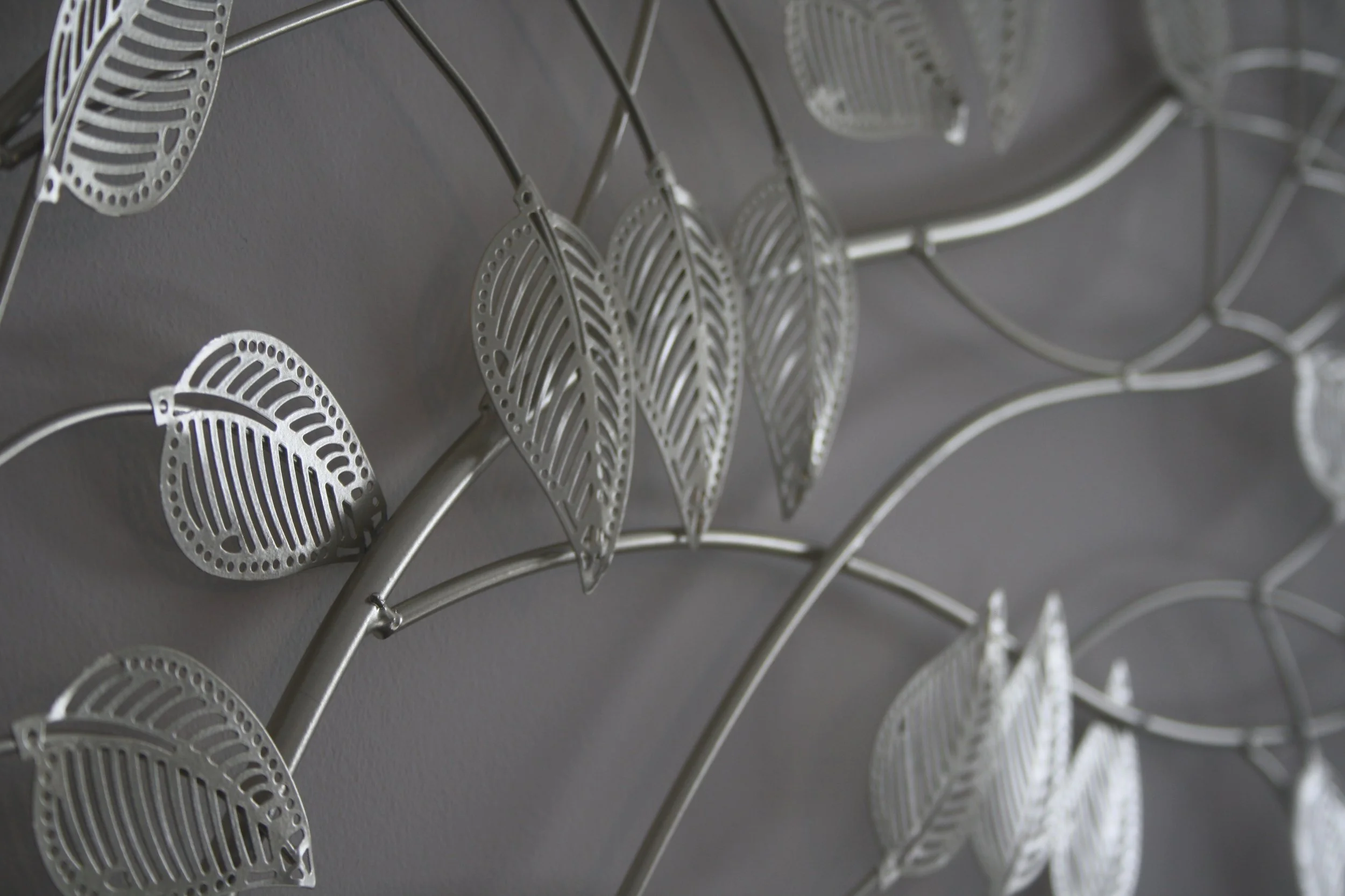 Decoração de Sala, Amadora.
Detalhe de decoração de parede com folhas de metal prateadas decorativas.