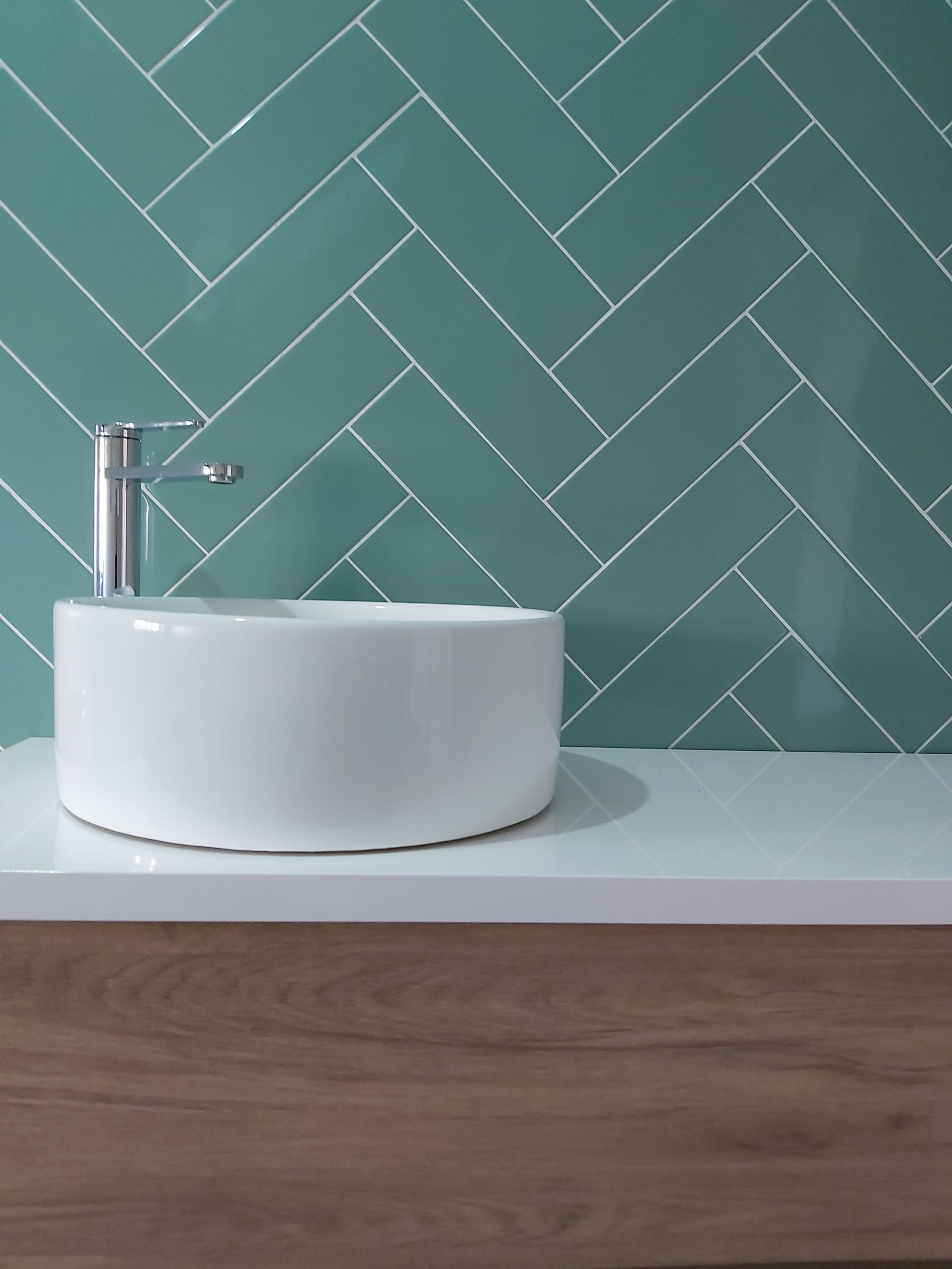 Casa-de-banho com apontamentos em madeira, e destaque de parede de lavatório com revestimento em azulejos com colocação em espinha