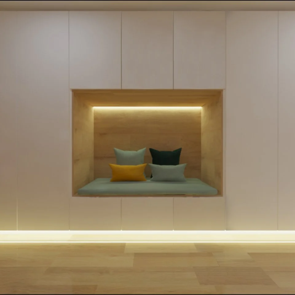 Nicho embutido na parede com almofadas coloridas e iluminação indireta.