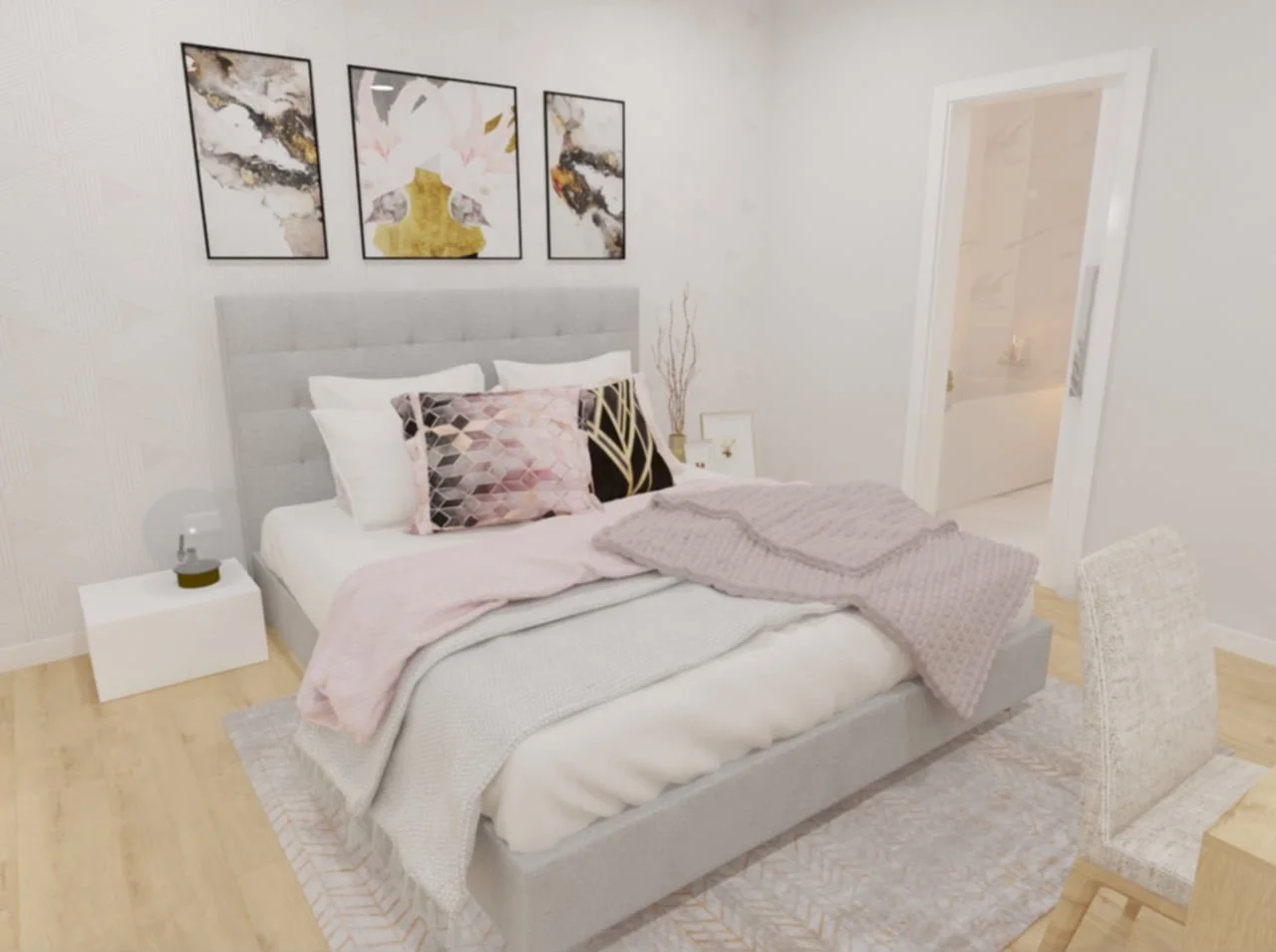 Quarto moderno com cama de cabeceira estofada na cor cinza, com roupas de cama em tons de rosa claro e branco, decorado com três quadros abstratos na parede, uma luminária ao lado da cama, um vaso com galhos decorativos, uma cadeira de fibra natural 