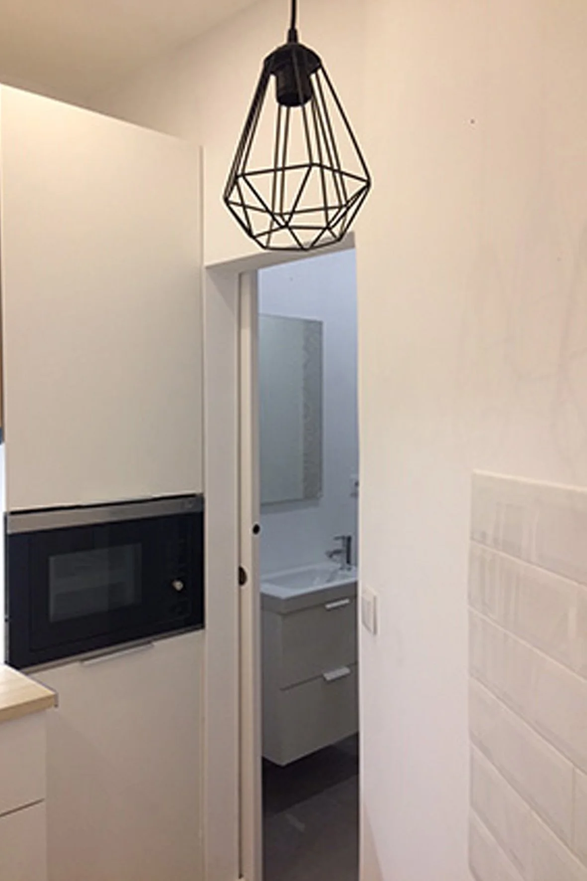 Lâmpada de pendente de decoração estilizada com estrutura de ferro na cozinha de apartamento.