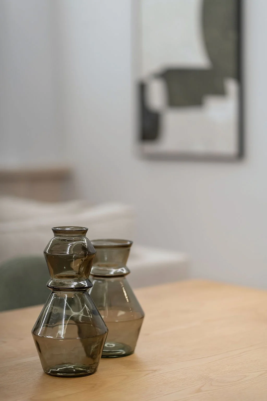 Vasos de vidro em uma mesa de madeira, com um espelho ao fundo na parede