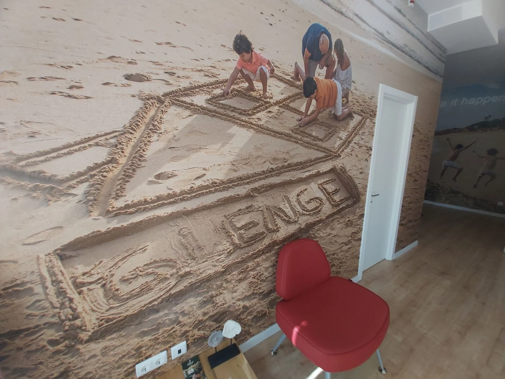 Projeto de Design de Interiores/Remodelação.
Perspetiva de parede com impressão grande formato de uma família na praia a brincar na areia e a desenhar uma casa e a palavra 'Glenge', transmitindo o conceito da área de actuação da empresa enquanto gest